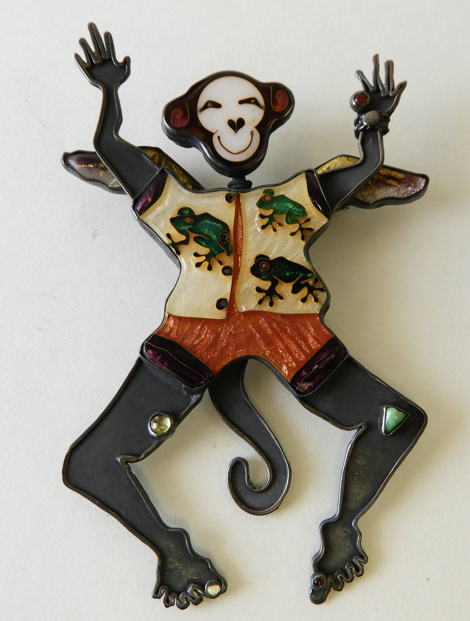 Flying Monkey Brooch by Kristin Holeman: Sterling silver, 22k and 24k flying monkey with cloisonne enamel face, wings, and outfit. Marked appropriately and signed on back. 4" tall. Property from the estate of Rosalie Coe Weir