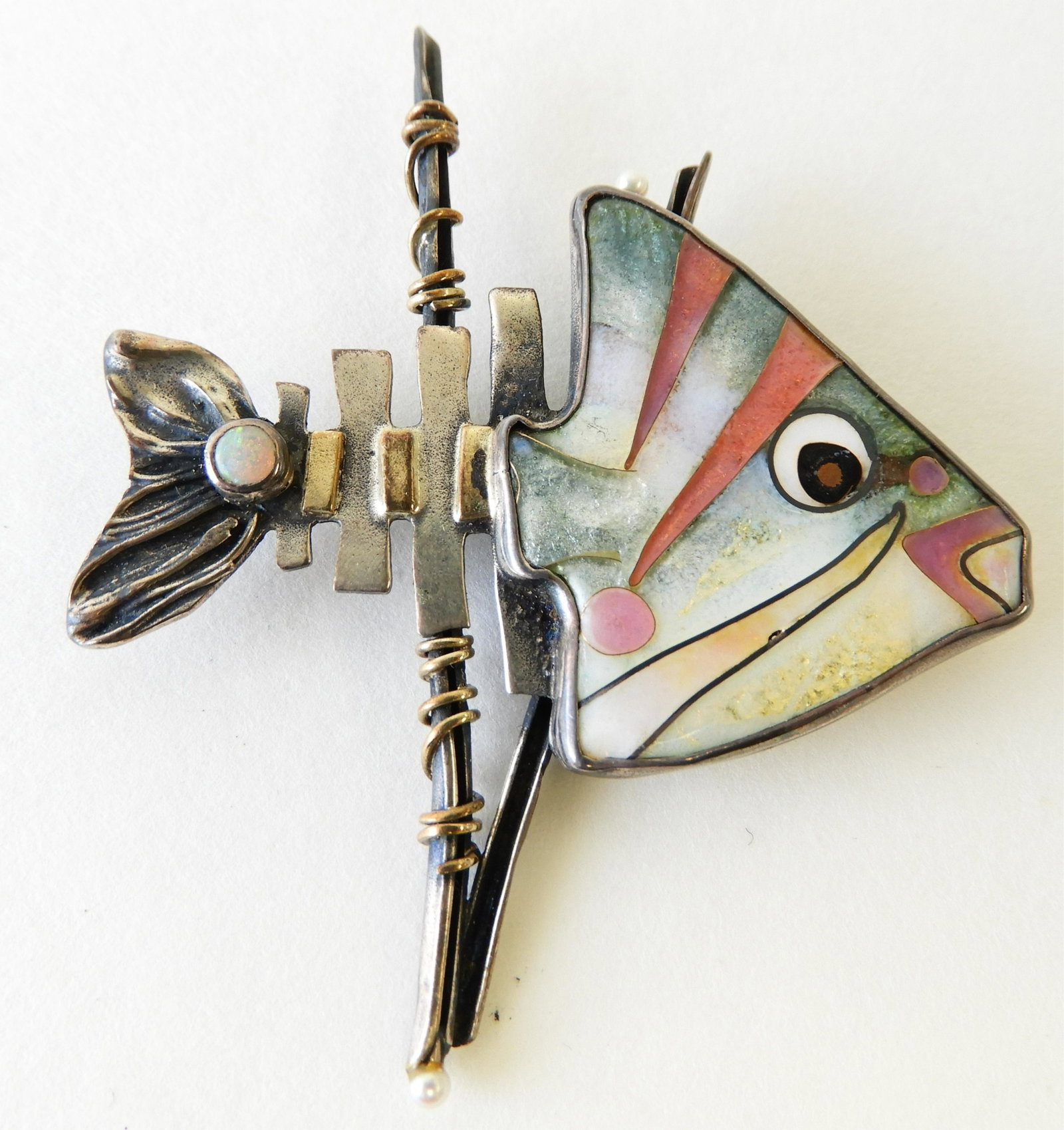 Sterling & 18K Bonefish Pin: Sterling silver bonefish pin with 18k yellow gold detail elements, opal tail accent, and cloisonne enamel face by Kristin Holeman. 2.25" x 2.75" Property from the estate of Rosalie Coe Weir