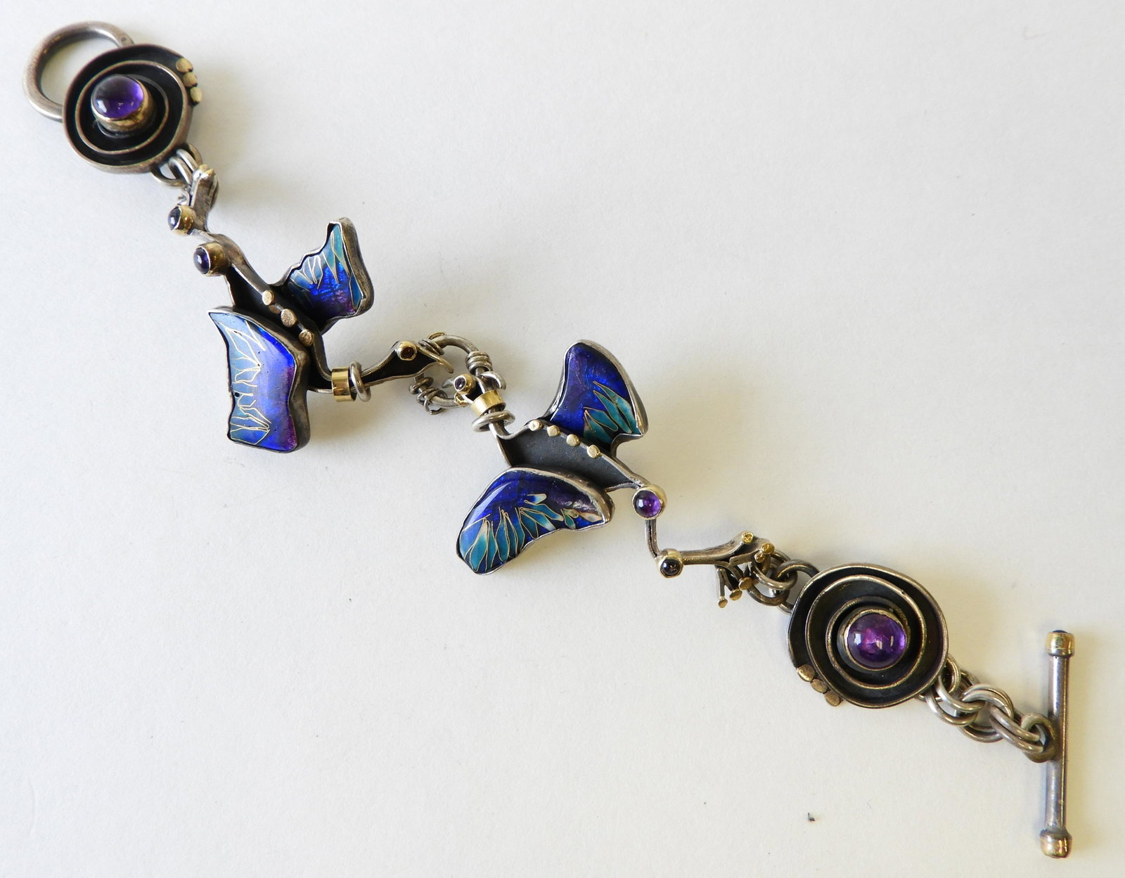 Crane Bracelet - Gold & Sterling Silver: Two cranes with beautiful blue and teal cloisonne enamel wings set in sterling silver. 22k and 24k gold elements. Designed by Kristin Holeman, signed & marked on back. 7.25" long Property from the est