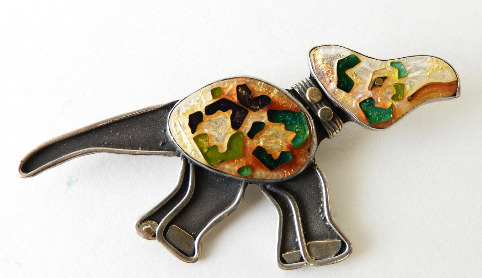 Dinosaur Brooch - Cloisonne Enamel: Similar to a triceratops, lovely orange, green, and purple cloisonne enamel body and head set in sterling silver with 22k and 24k gold elements -- designed by Kristin Holeman. Marked and signed on bac