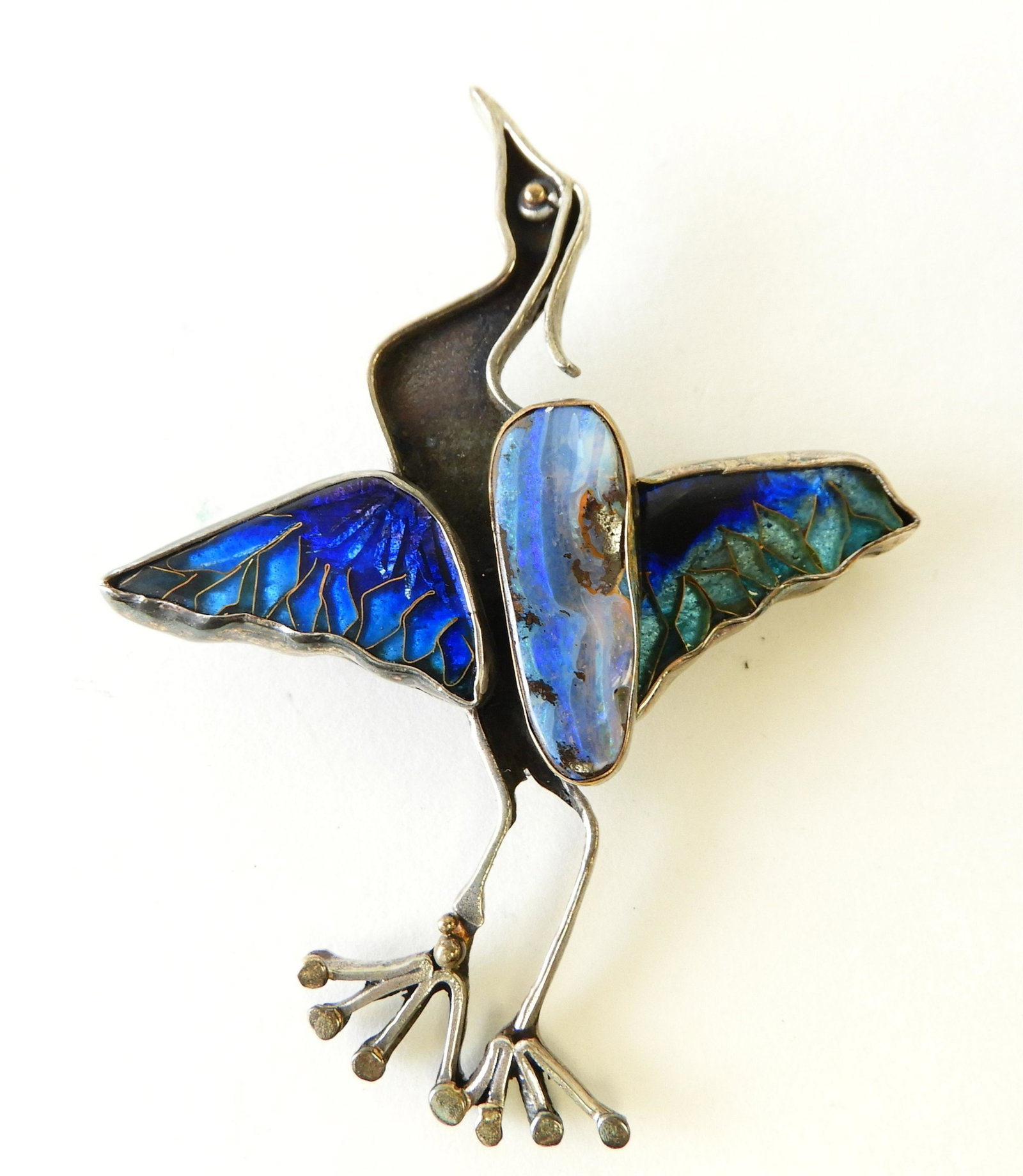 Crane Brooch - Sterling, 22k: Lovely sterling silver crane brooch with blue and purple cloisonne enamel wings and hard stone body with 22k yellow gold details elements by Kristin Holeman. Signed and marked on back. 3" tall. Proper