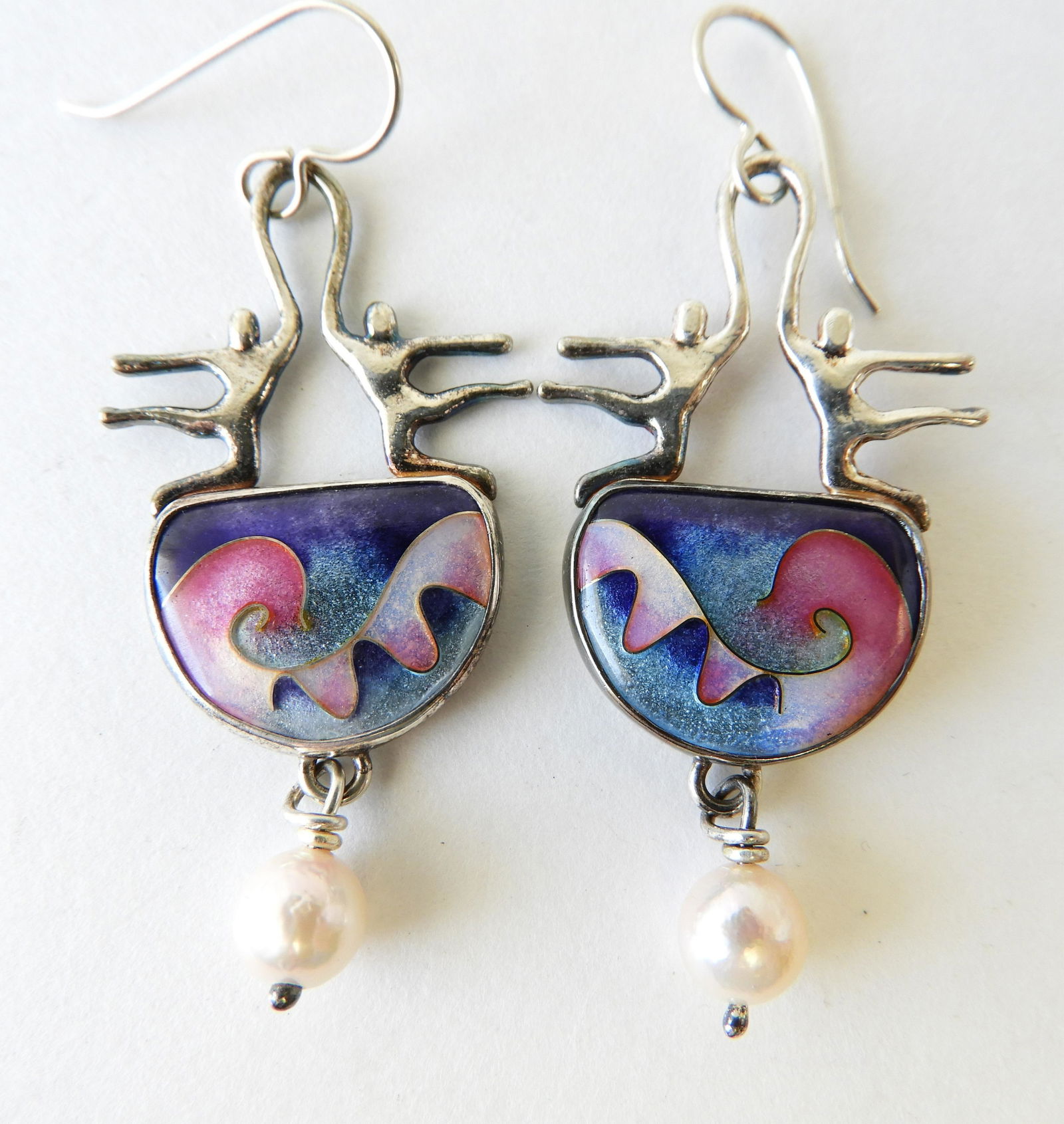 Dancing Figure Earrings by Ricky Frank: Silver tone figures atop cloisonne enamel waves with drop beads signed R. Frank, '93. 2" long Property from the estate of Rosalie Coe Weir