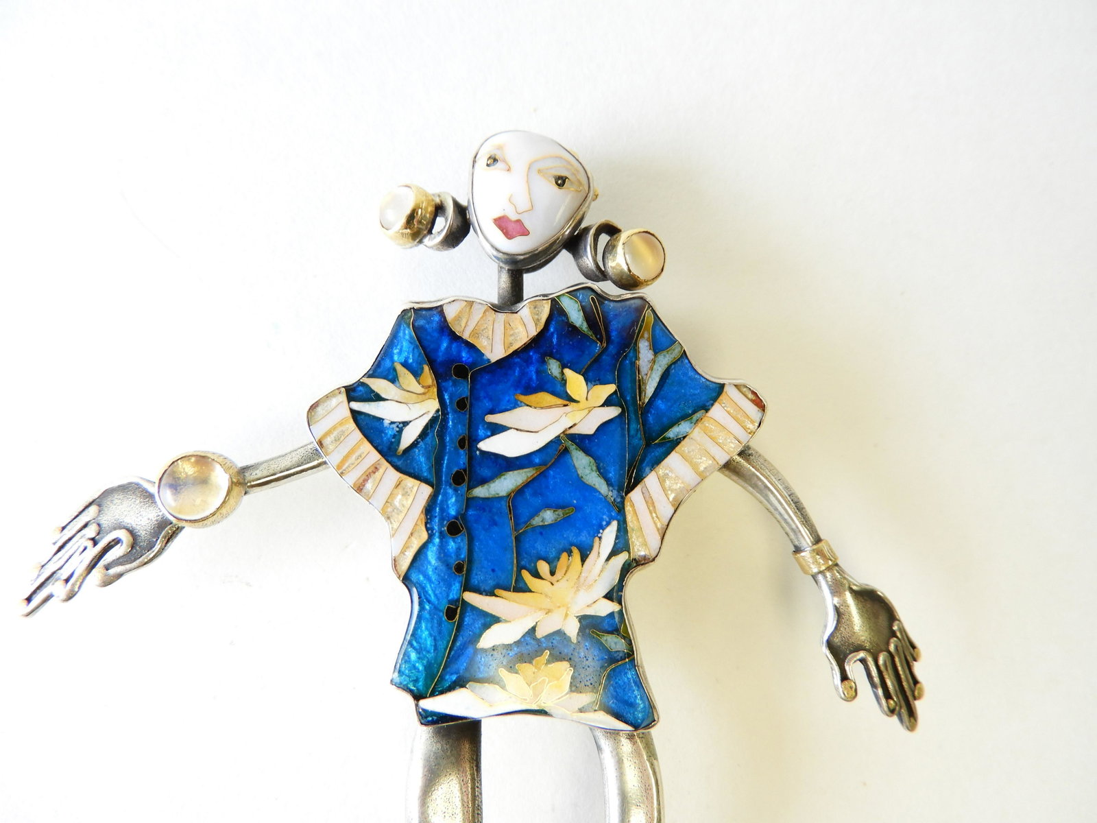 Sterling & 24K Gold Figure Brooch: Sterling silver and 24k yellow gold figure wearing a blue Hawaiian cloisionne enamel shirt by Kiristin Holeman. Signed and marked on back. 4" tall Property from the estate of Rosalie Coe Weir