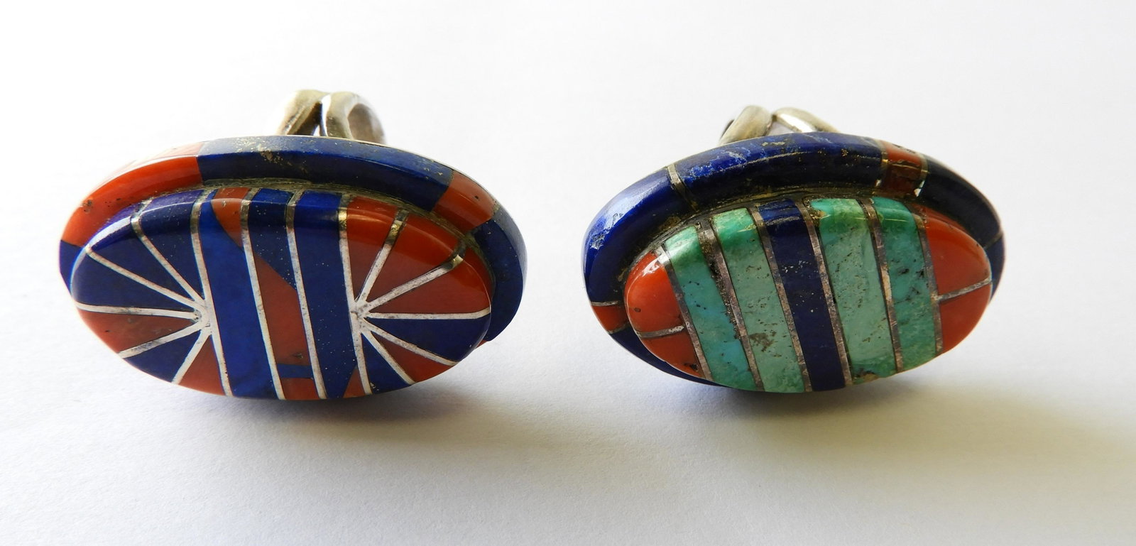 Geometric Hardstone Rings: Sterling silver rings with geometric designs consisting of lapis, turquoise, and red hardstone. Signed "AB" Both size 7. Tops are 1.25" long Property from the estate of Rosalie Coe Weir