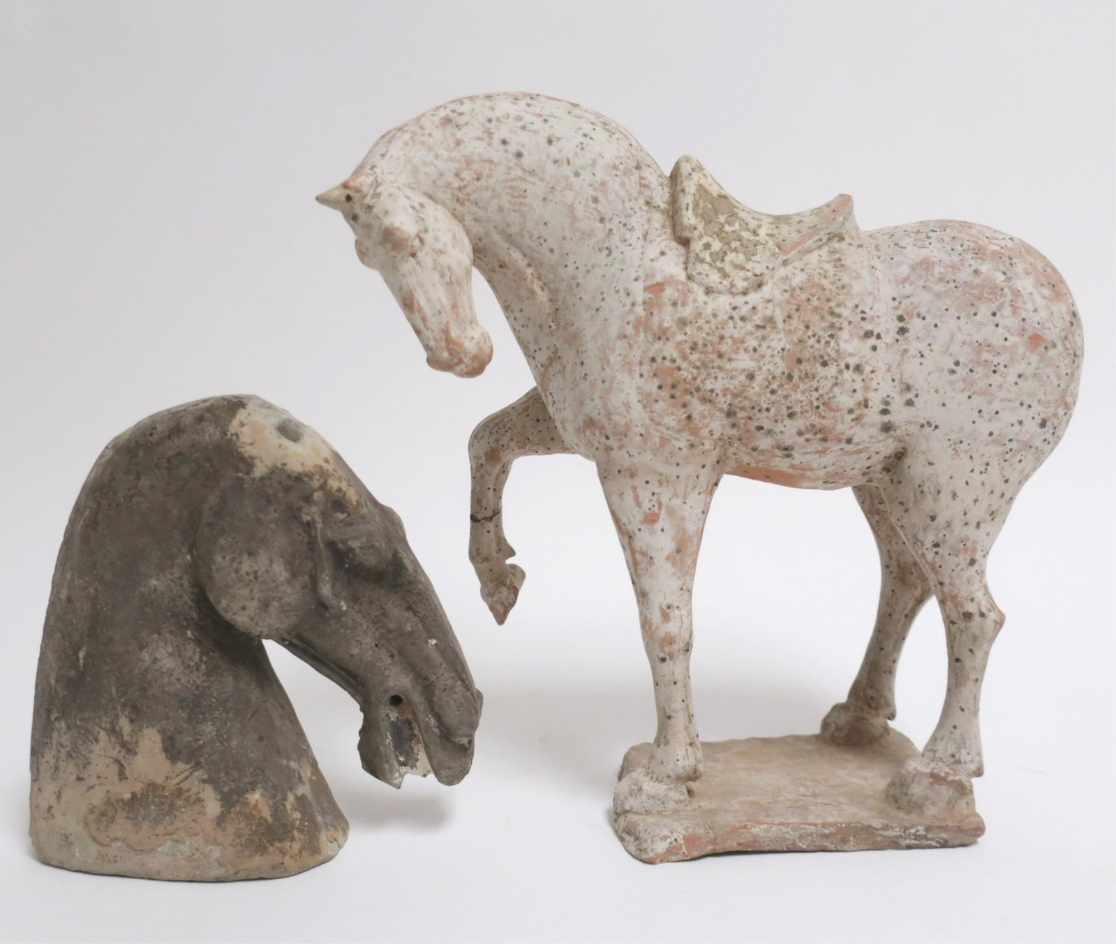 Tang Style Standing Horse and Horse Head: Tang style saddled horse with raised leg in grey white and a nicely formed horse head. 12" high and 7 1/2" high Litchfield Auctions is honored to offer Selections from the Collection of Peter Tillou. 