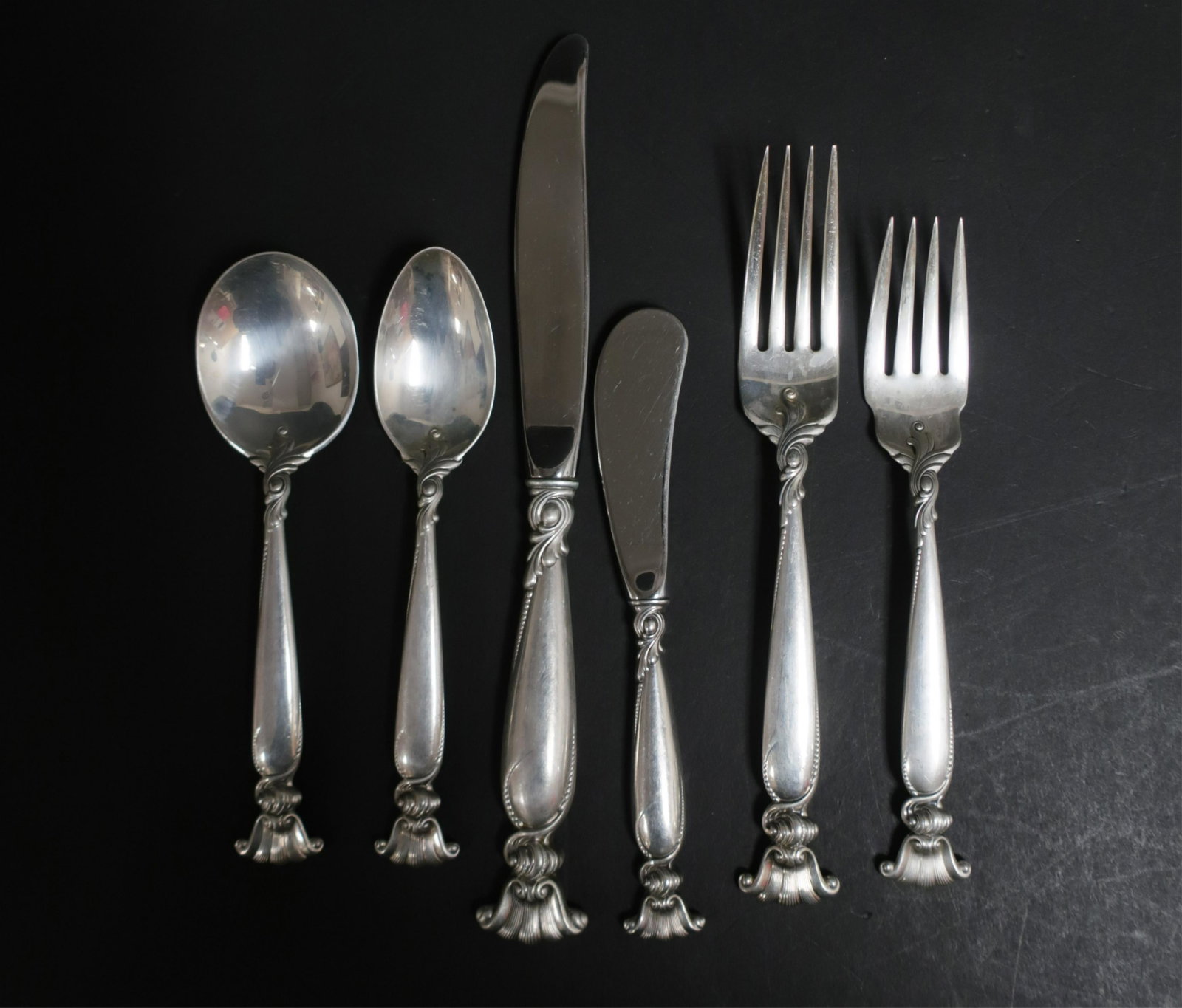 Wallace Sterling Silver Flatware Service for 12: "Romance of the Sea" pattern. approximately 83 oz weighable silver, comprises of dinner forks, soup spoons, lunch/salad forks, tea spoons, butter spreaders, plus 5 serving pieces. (77 pcs total) Salad