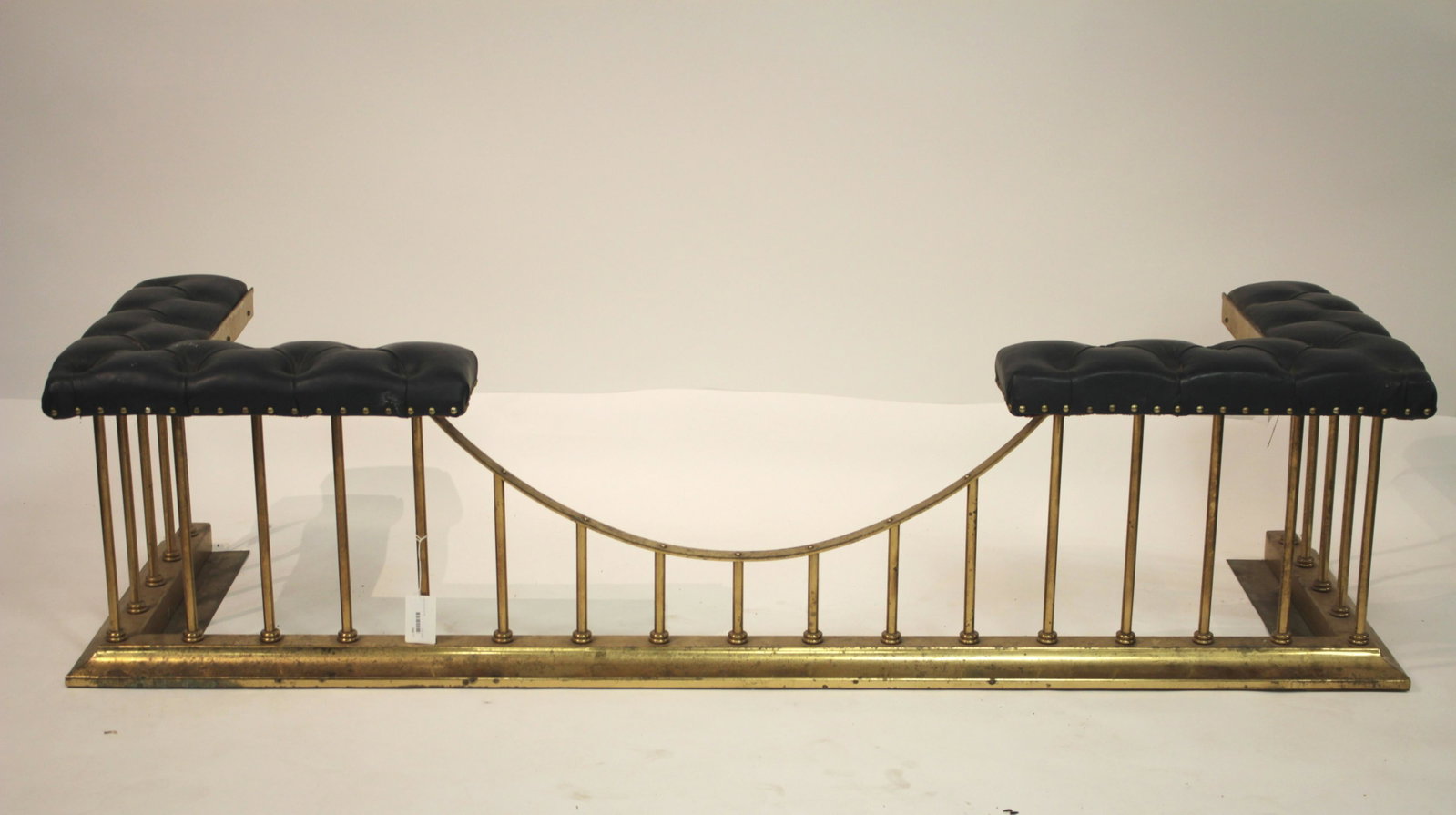 George III Style Brass Fire Bench: Buttoned blue leather upholstery. 19 H x 76 W x 24 D Selections from the Collection of Dr. John A. Downey of Manhattan and Sharon Connecticut. Born and raised on a farm in the prairies of Saskatchewan