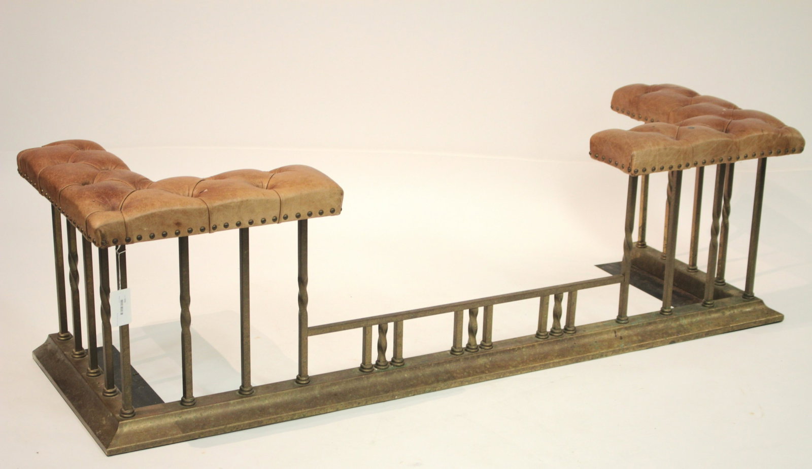 English Brass Fire Bench: Button tan leather upholstery 19.75 H x 69 W x 21.75 D Selections from the Collection of Dr. John A. Downey of Manhattan and Sharon Connecticut. Born and raised on a farm in the prairies of Saskatchew