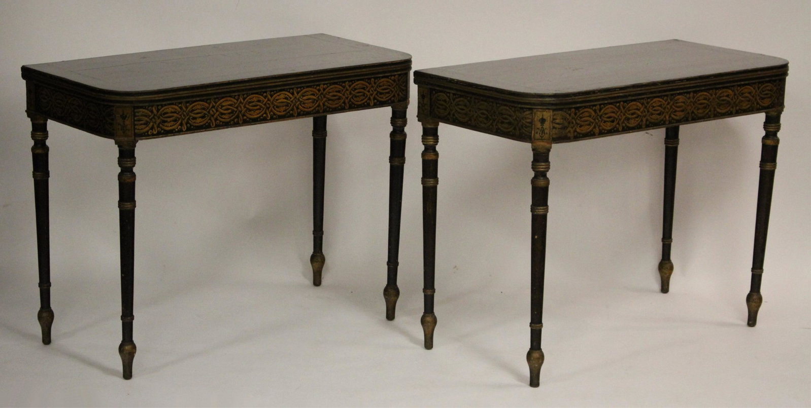 Pair of Georgian Game Tables, c 1800: Gilt stencil work on black painted ground, painted tops, the interiors with newly replaced gold tooled green leather. Protective glass tops. 30h x 38L x 19d (closed) (QLIV2062/2)(WT)