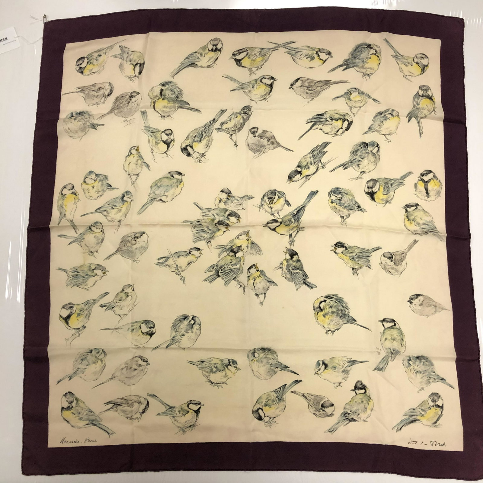 Hermes 'Les Mesanges' Silk Scarf: Twill silk scarf titled Les Mesanges (tit bird) designed by Xavier de Poret, circa 1960. Signed "Hermes Paris" and "X de Poret" in black at the bottom of the scarf. Cream ground with violet purple bor