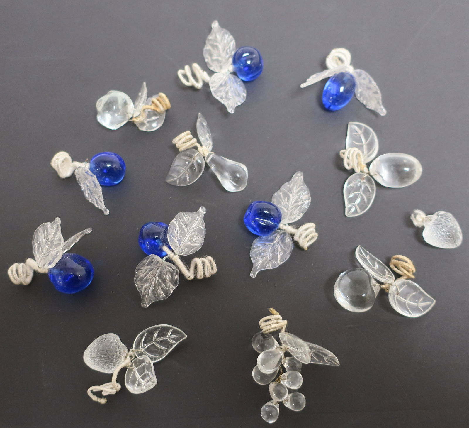 12 Placecard Holders: 12 Placecard Holders, blue and clear glass, berries and leaves (12 pc.) Dimensions: Approx. 2 1/2" x 1 1/2" (WECH1244/12)(WT)