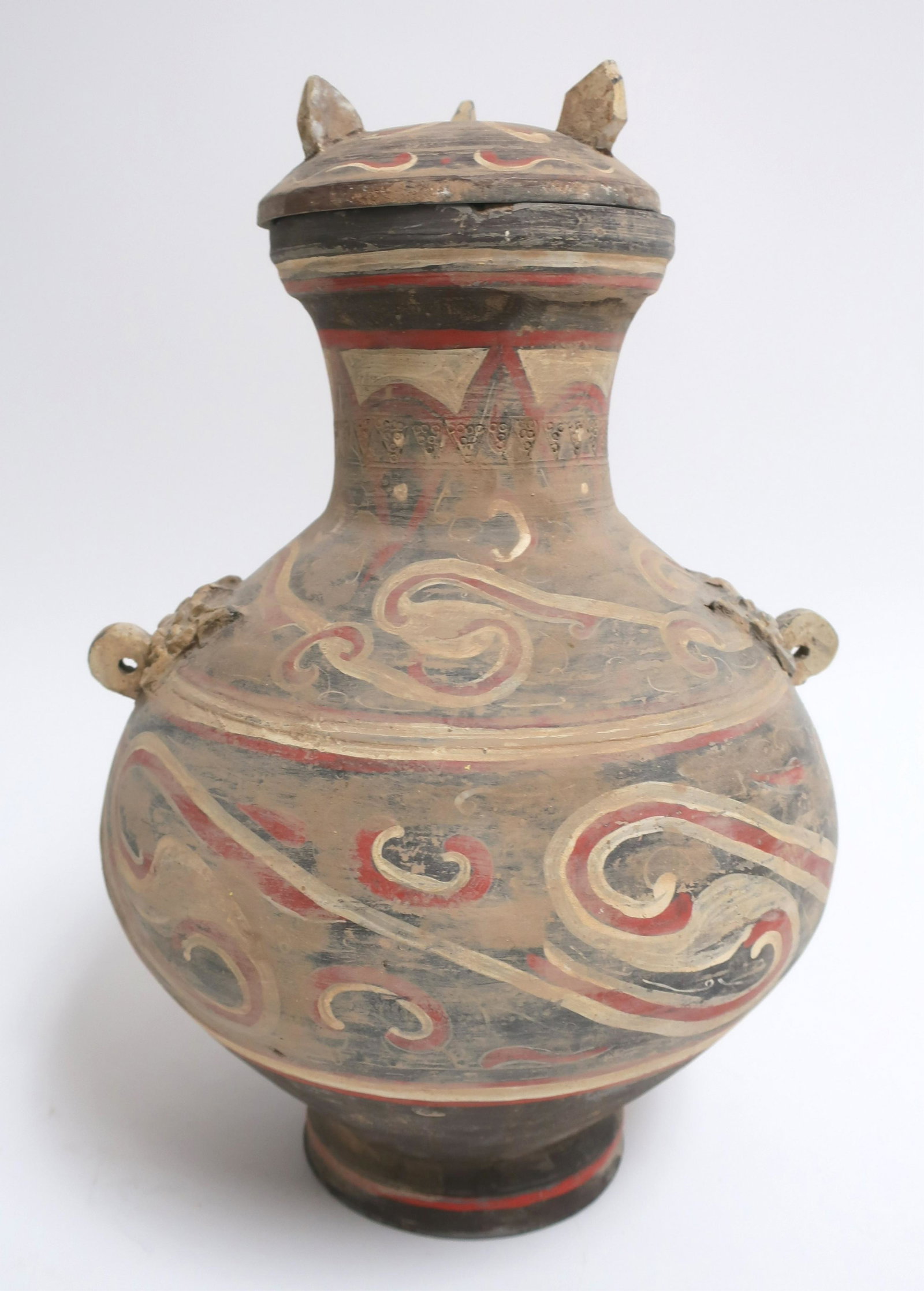 Small Chinese Han Terracotta Hu: In the style seen in the Western Han dynasty (206 BCE - 9 CE). Very well formed and painted overall in the style of the period with red, black and white pigment/slip. Molded masks od detailed relief a