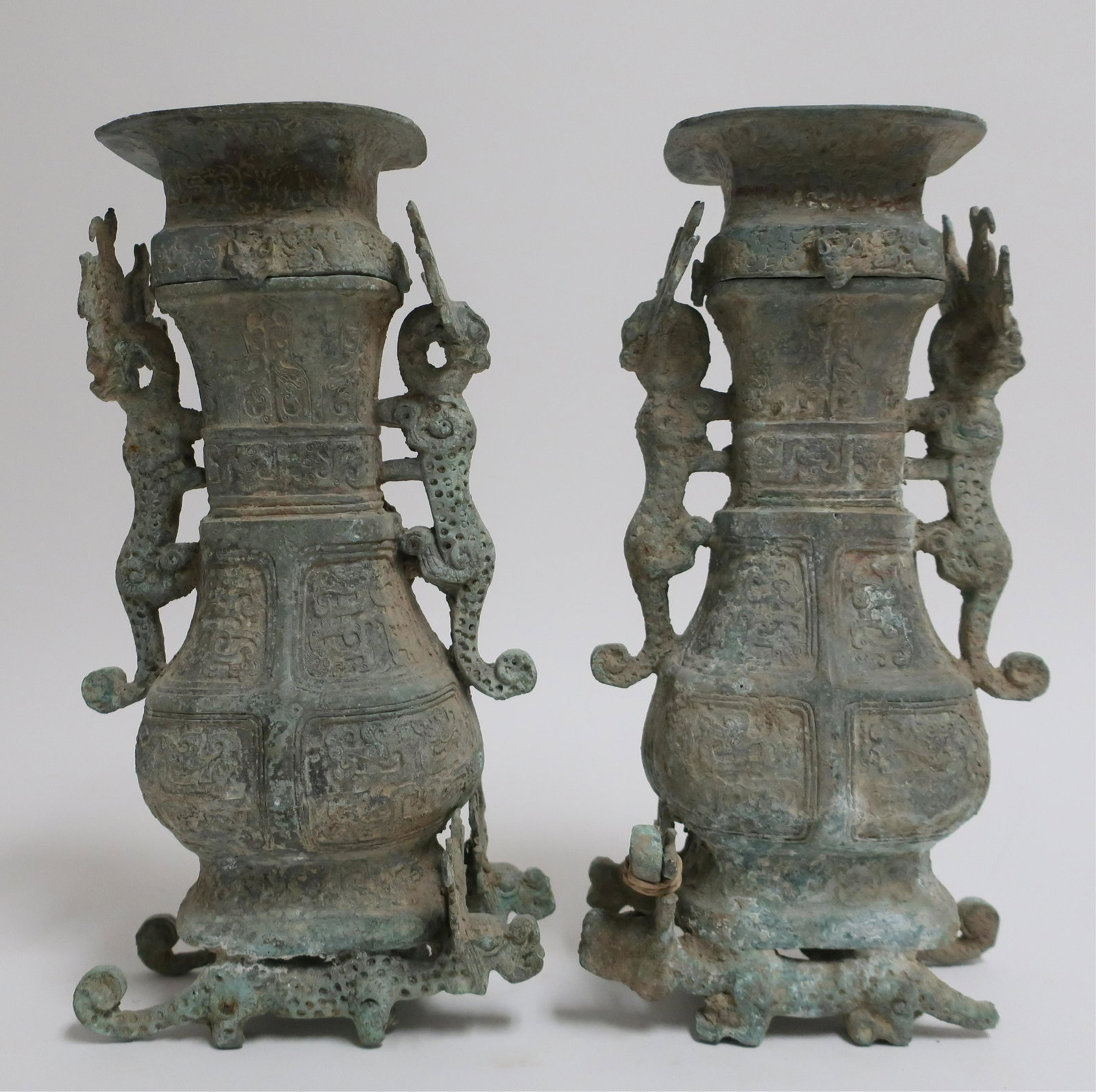Pair Zhou Dynasty Style Bronze Fanghu: Wonderfully cast and patinated lidded pair of bronge ornate Fanghu in the Eastern Zhou Dynasty (770 â€“ 221 B.C.) style. Each with handles and supports in the shape of mythical beasts. The loe be