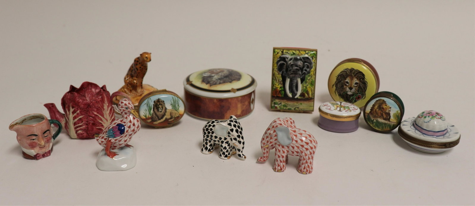 Group of English & Continental Porcelains, Etc.: Porcelains, ceramic boxes, and figurines. Including two Herend figurines, Lynn Chase box, 2 Limoge boxes, 5 Halcyon Days boxes, Toby jug, miniature pot, Koesis elephant (PEPA150/13)(MS) Dimensions: La