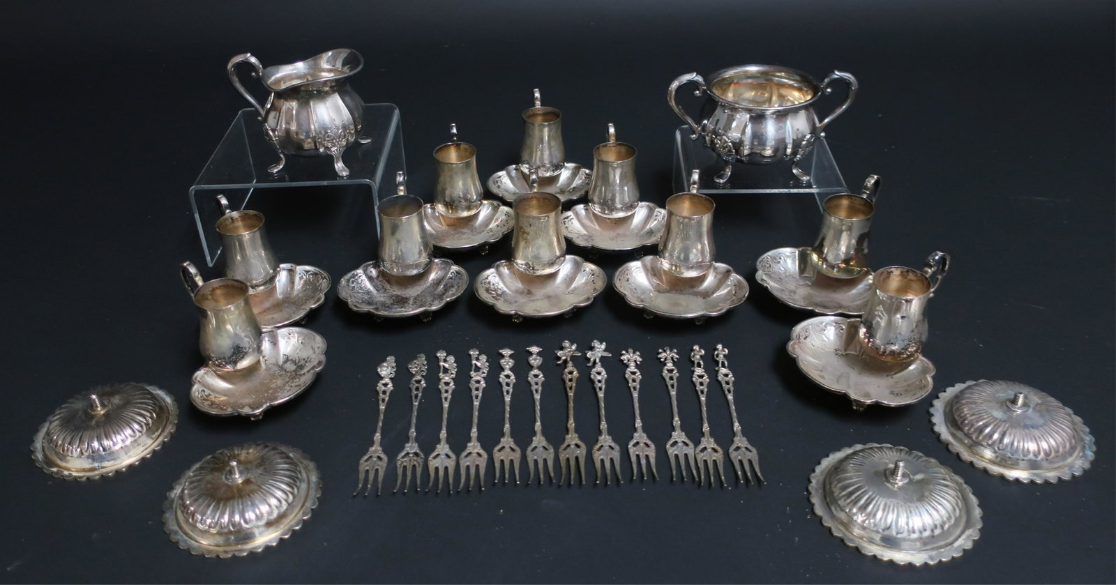 28 Pieces of .800/.830 Silver: 28 Pieces of .800/.830 Silver, comprises 10 cup/plate combinations, sugar & creamer, 12 hors d'oeuvres picks and 4 half gilt circular dishes with screw back. 43.75 ozt (28 pc.) (DORI2928/28)(WT) Dimen