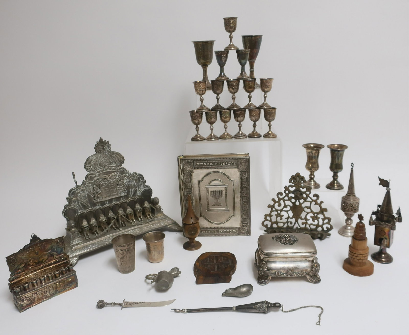 Lot of various Silver Judaica plus others: Includes 19th c Polish Etrog Box, small Menorah, 2 spice towers, 18 cups, a pointer and small knife 36 OZT weighable silver. TOGETHER with non-silver pieces; a book cover, 2 wine cups, a brass Menorah