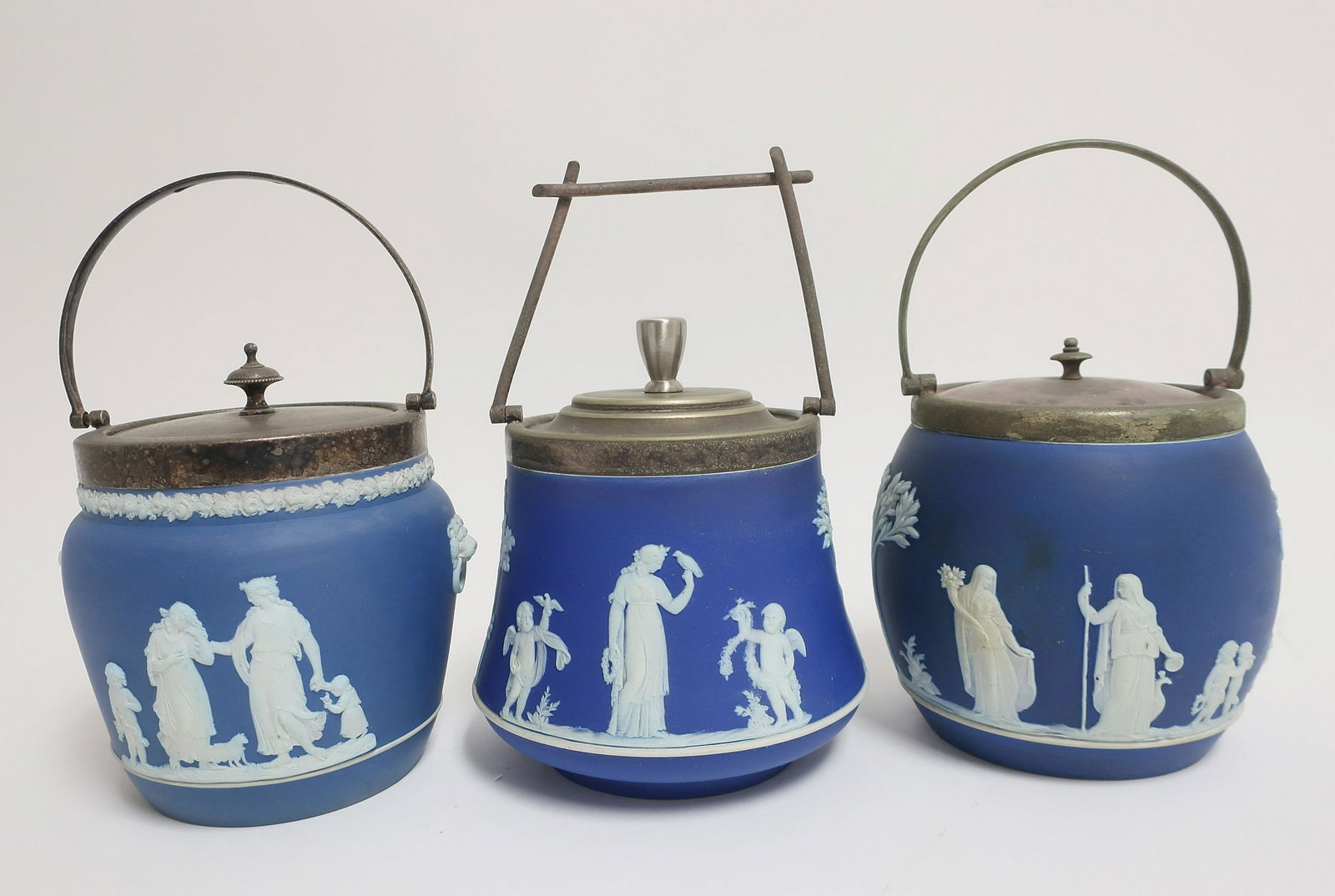 3 Wedgwood Jasper Dip Biscuit Jars: 3 Wedgwood Jasper Dip Biscuit Jars, dark blue ground, silverplate tops, with impressed mark & Made in England (3 pc.) (ZWED4435/3)(WT) Dimensions: Approx. 5 1/2" H without handles x 5 1/2 dia. Part I