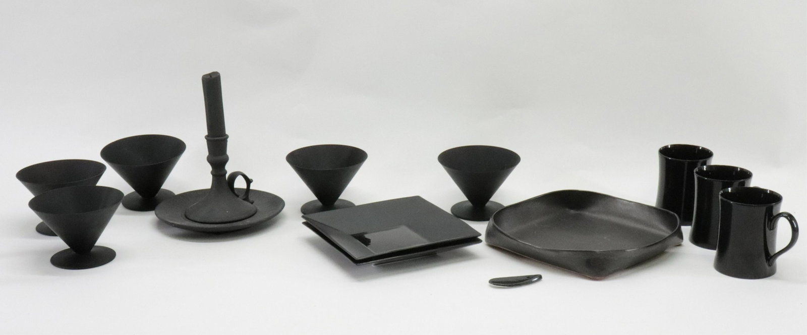 12 Matte Black & Glossy Porcelain Items: 12 Matte Black & Glossy Porcelain Dishes, Cups & Candlestick, 2 square plates by Gucci, 3 cups Fitz & Floyd Dimensions: Gucci 7" square, Sherbets/Martini Glasses 3 1/4" H x 4 3/4" dia. (EBAZ5192/12)(W