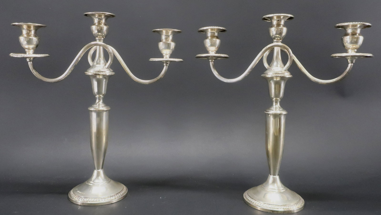 Pair Sterling Three Light Candelabra: Two scrolled arms, three candleholders each. Two part: arms threaded to standards. Weighted bases. Dimensions: 14"H x 12.75W Property from a Manhattan collection (LENG7774)(JP)