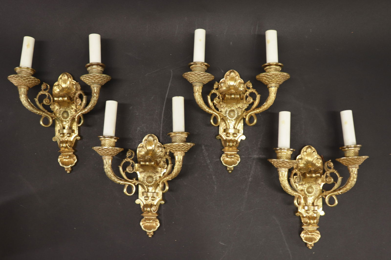 4 Neoclassical Regency Style Gilt Metal Sconces: 4 Neoclassical Regency Gilt Metal 2 Arm Electrified Sconces, features intricate sunflower, scroll and leaf motifs, verso impressed "GH" and "AV" numbered 767, includes 8 pale gold toned silk drum shad