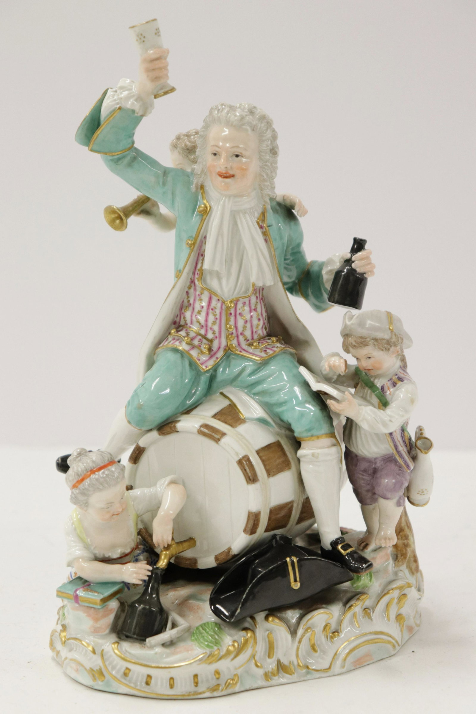 Meissen Porcelain Group, "The Revelers": Meissen Porcelain Group, "The Revelers" depicts a gentleman seated on a wine cask drinking wine and accompanied by children and a faun playing a horn, underglaze blue crossed swords with dot mark Dime