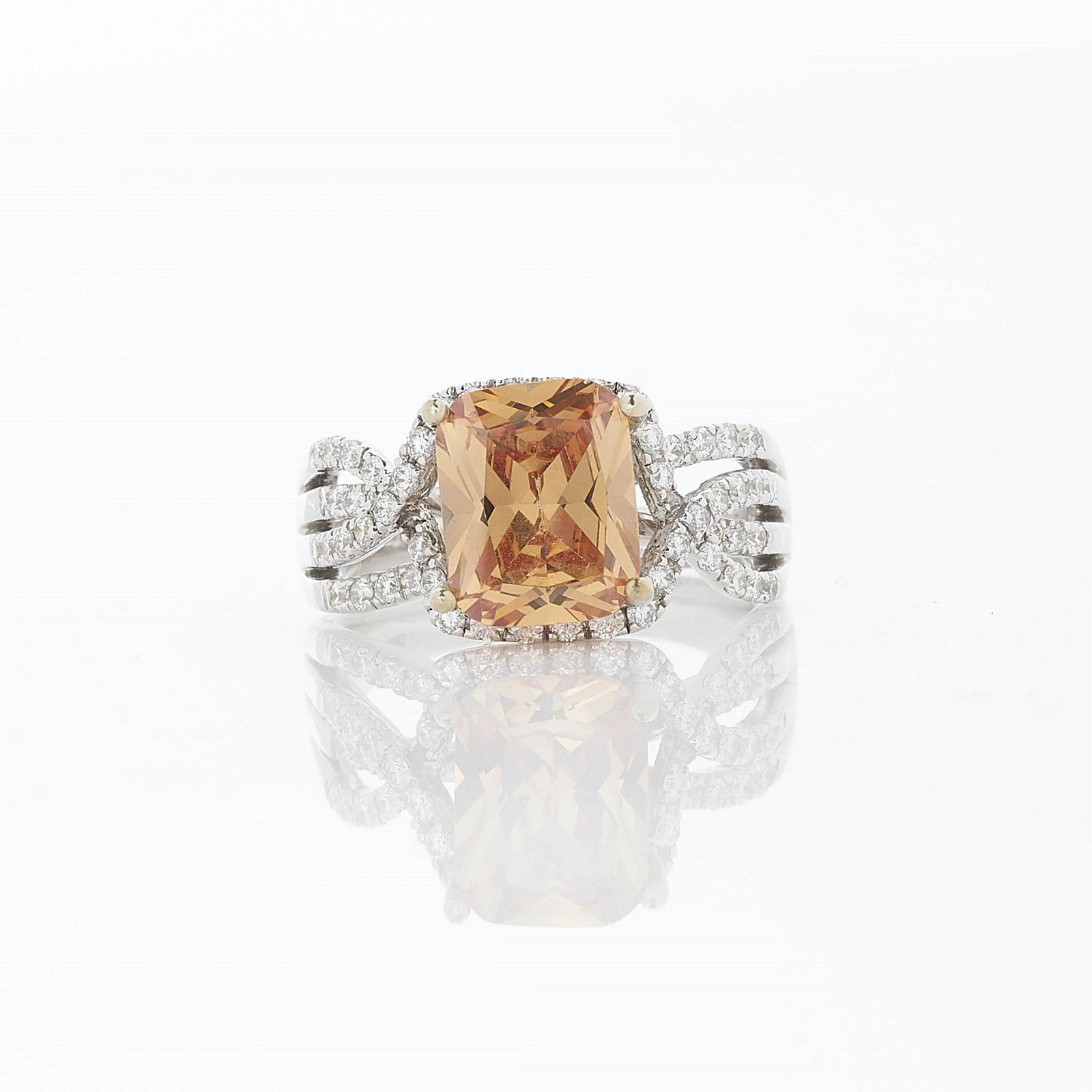 5 ct Champagne Zircon Ring: Prong set natural zircon of champagne coloring measuring 10 x 8.03 x 4 mm, weighing 5.0 ct. Accented by 54 round channel set diamonds measuring weighing 0.32 ct. Set in 14k white gold, shank stamped 1