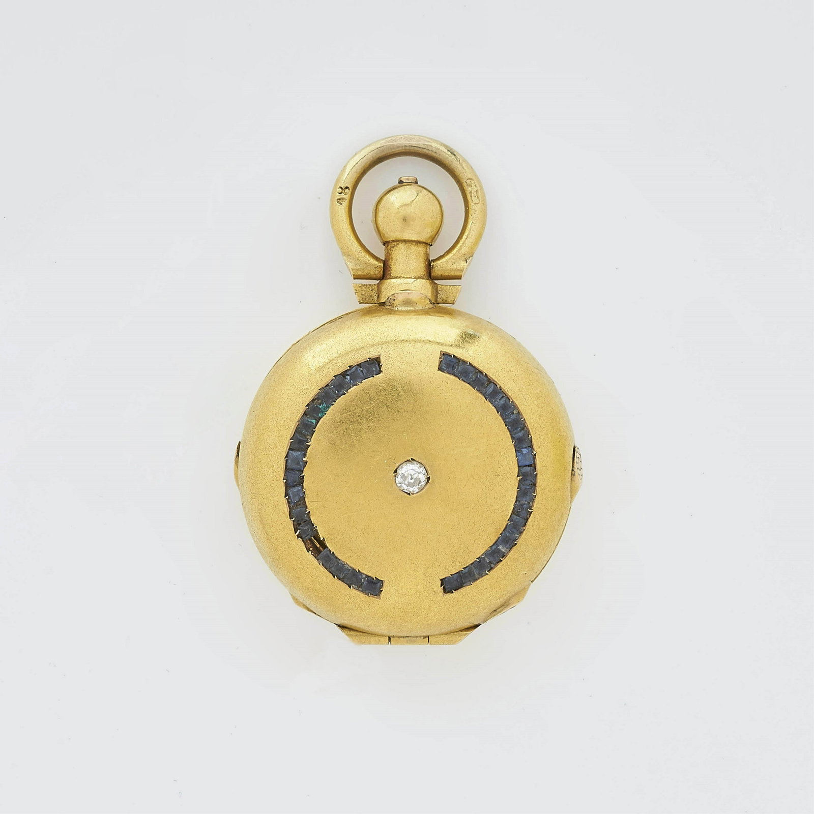 18K Yellow Gold Locket: A vintage 18k yellow gold double locket with 2.10 mm center diamond, flanked by two curved rows of sapphires. Marked 18k on bale. Gross weight of 9.5 grams. Dimensions: 1 x 1.25" Property from a Park 