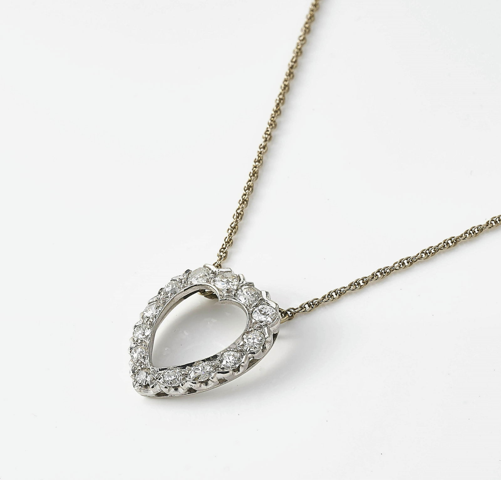 Diamond Open Heart Pendant: An open work, heart shaped pendant with (13) diamonds measuring ~2.09 mm to 3.42 mm. Affixed 14k white gold Prince of Wales link chain, stamped on grommet. Stamped sterling on clasp. Both pieces stamp