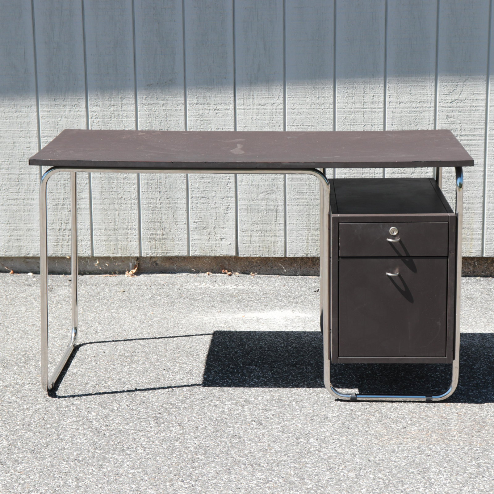 Mid Century Modern Chrome Desk: Deep brown laminate. Chrome frame. Dimensions: 25.5 deep by 51.25 wide by 29.75 high Property from a South Kent, CT collector. (JOHN673)(SCL)