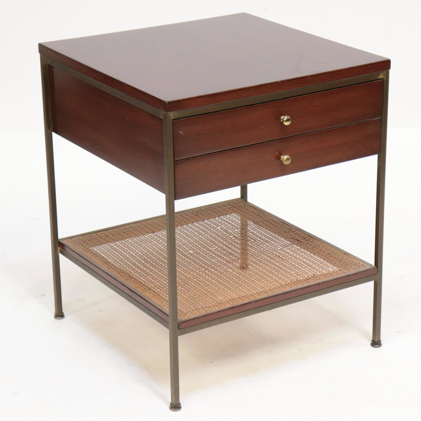 Paul McCobb 2-Drawer Stand, Irwin Collection, Bedside: Paul McCobb 2-Drawer Stand, brass mounted mahogany with caned platform stretcher, metal tag "The Irwin Collection, Paul McCobb Calvin, Grand Rapids" Dimensions: 24 1/2" H x 20" sq. Property from a Nor