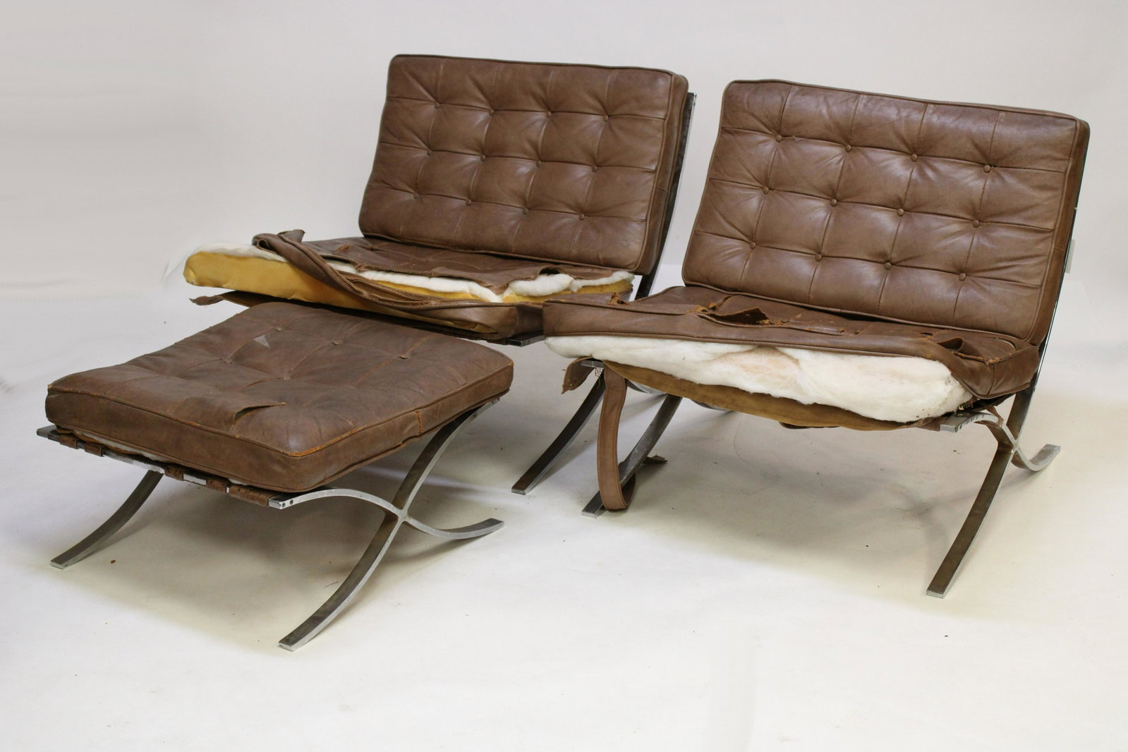 Pair of Knoll Barcelona Chairs & Ottoman: Mies van der Roe for Knoll Barcelona Chairs and matching ottoman with tan color upholstery. Dimensions: 29.5 x 32 x 28 (chair frame) 24 x 24 x 11 (ottoman frame) Property from a South Kent, CT collect