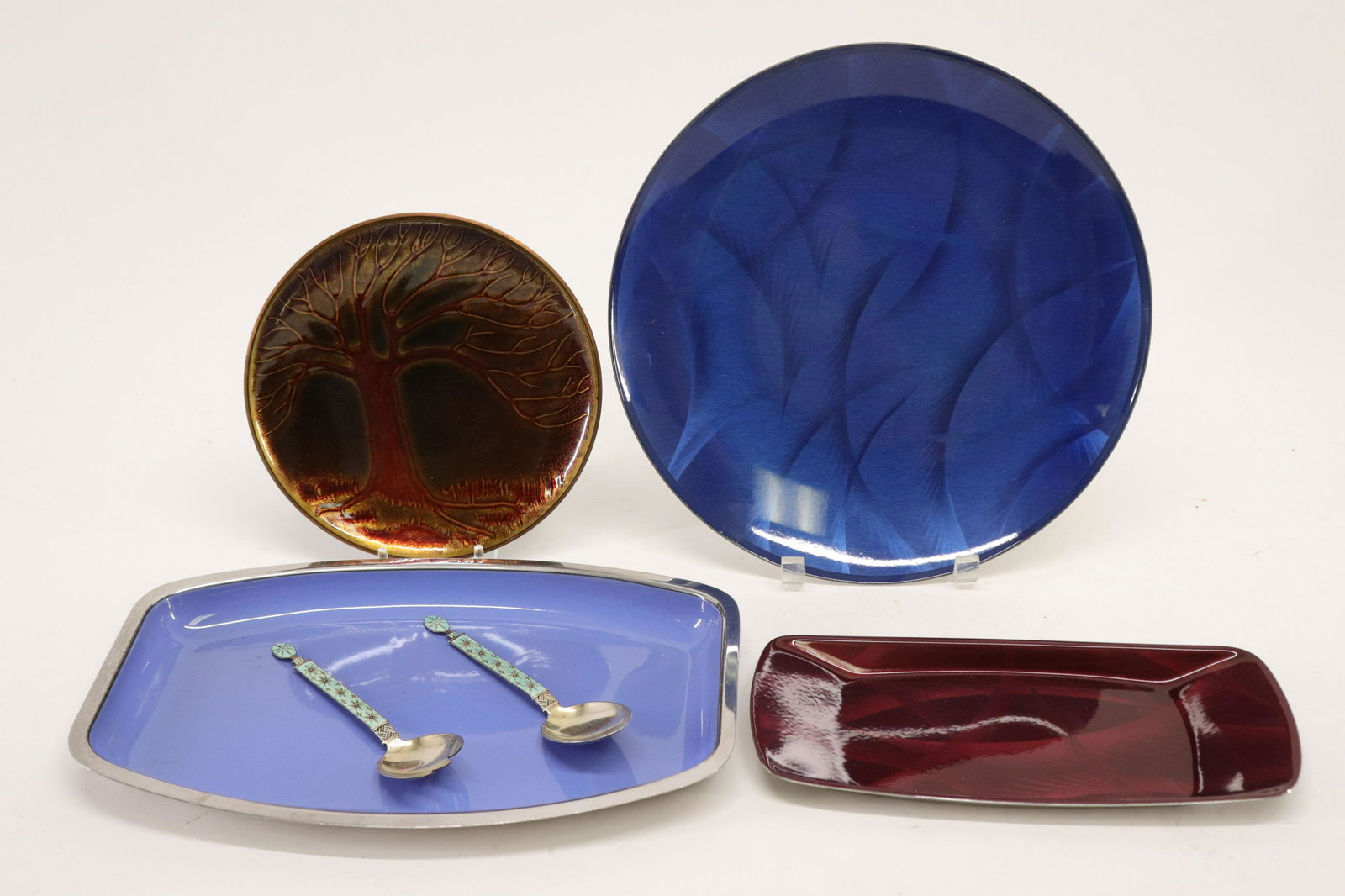 6 Modern Norwegian Enamel Pieces: 6 Modern Norwegian Enamel Pieces, comprises: Tostrup sterling silver and enamel serving fork & spoon, David Andersen and 3 Cathrineholm enamel on copper trays Dimensions: Spoon 7" L, Circular tray/dis