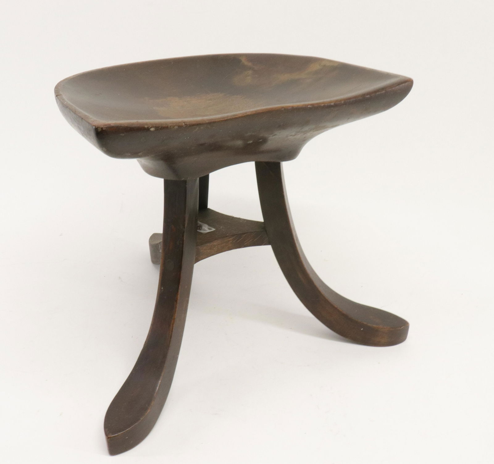 Mahogany Saddle Seat Thebes Style Stool: Three splayed legs, oak stretcher part. Dark stained. Smith & Watson Antiques, English Furniture, New York NY label on underside. Dimensions: 14"H x 17W @ legs seat front Property from a Northwest CT
