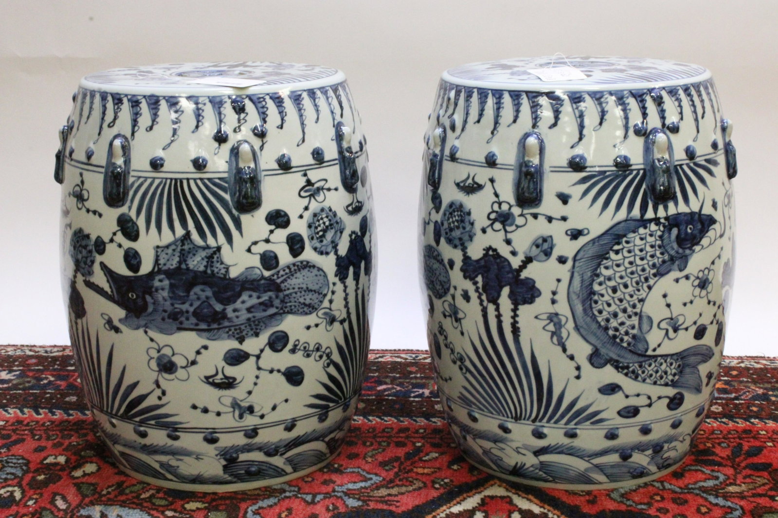 Two Blue and White Yuan Style Garden Stools: Two Blue and White Yuan Style Garden Stools. Matched pair of porcelain garden stools with Yuan-era fish motif and a pierced top. 20th century Dimensions: 17" x 13" diameter Property from the Estate of
