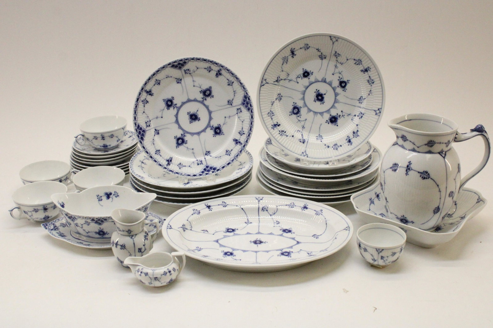 Group Royal Copenhagen Porcelain Dinnerware: Grouping Royal Copenhagen Porcelain Dinnerware, blue fluted half-lace and other patterns, comprises: 11 dinner plates, 2 patterns ,9 1/2"/10" dia., depth various (one with rim chip); 2 luncheon plates