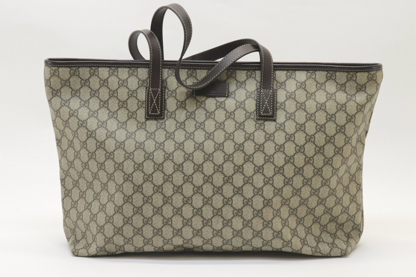 Gucci - Tote GM: Gucci Tote GM coated GG canvas exterior, canvas interior, dark brown leather handles. Top zip. Serial number 189669-002123 Dimensions: 34x36x13cm