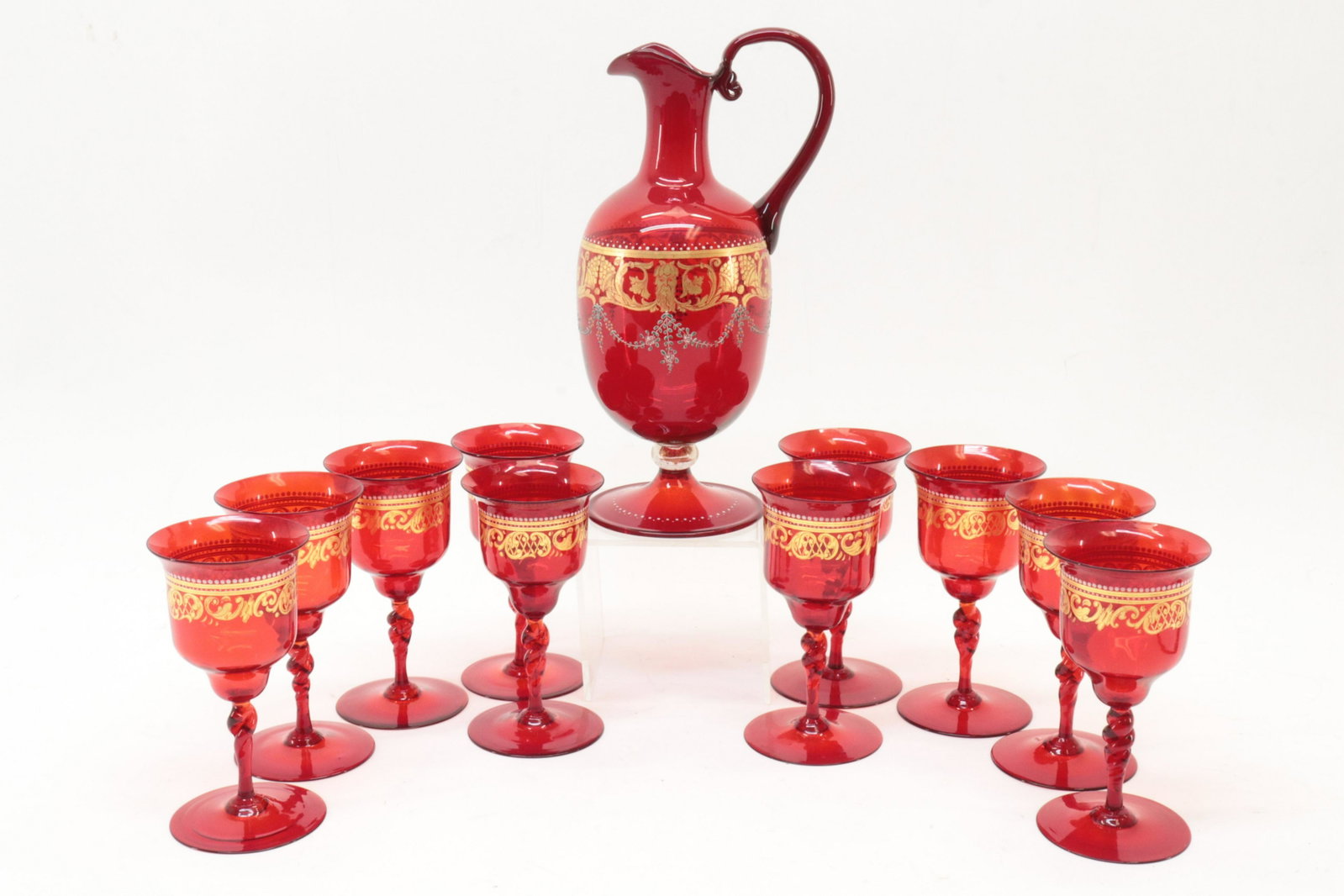 Bohemian Cranberry Pitcher and Wine Glasses: Bohemian Cranberry Pitcher and Wine Glasses, paint and gilt decorated (APOU2283)(MM) Dimensions: glasses 6", Pitcher 11 1/2" From a Litchfield Connecticut Home