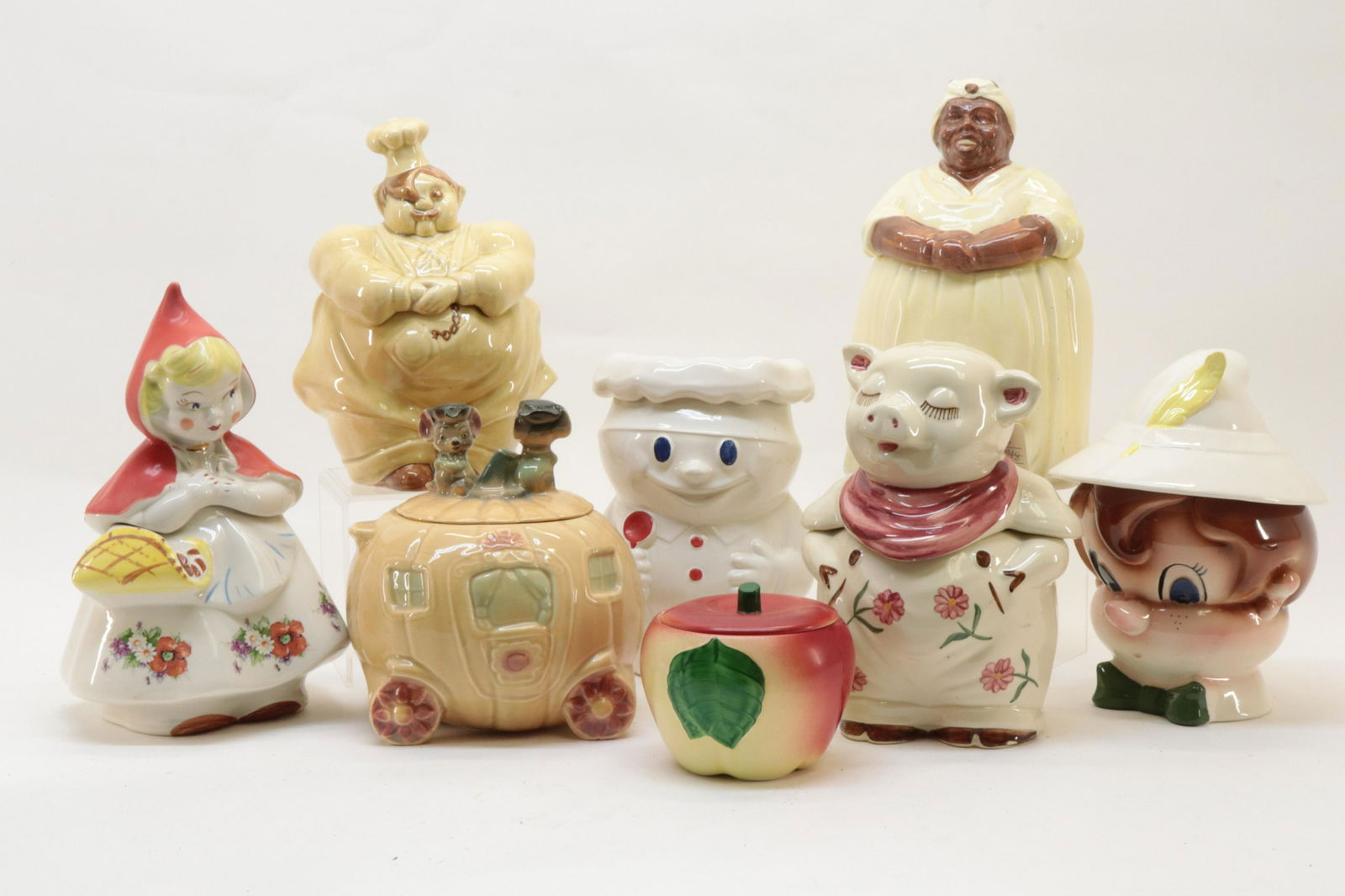 8 Pottery Cookie Jars, incl. McCoy: 8 Pottery Cookie Jars, includes: Cinderella's Pumpkin Coach W32 43A (chip to lid rim); Baker 183 McCoy (tape residue to bottom); Pinocchio, made in Calif.(nick to glaze of feather and interior rim chi