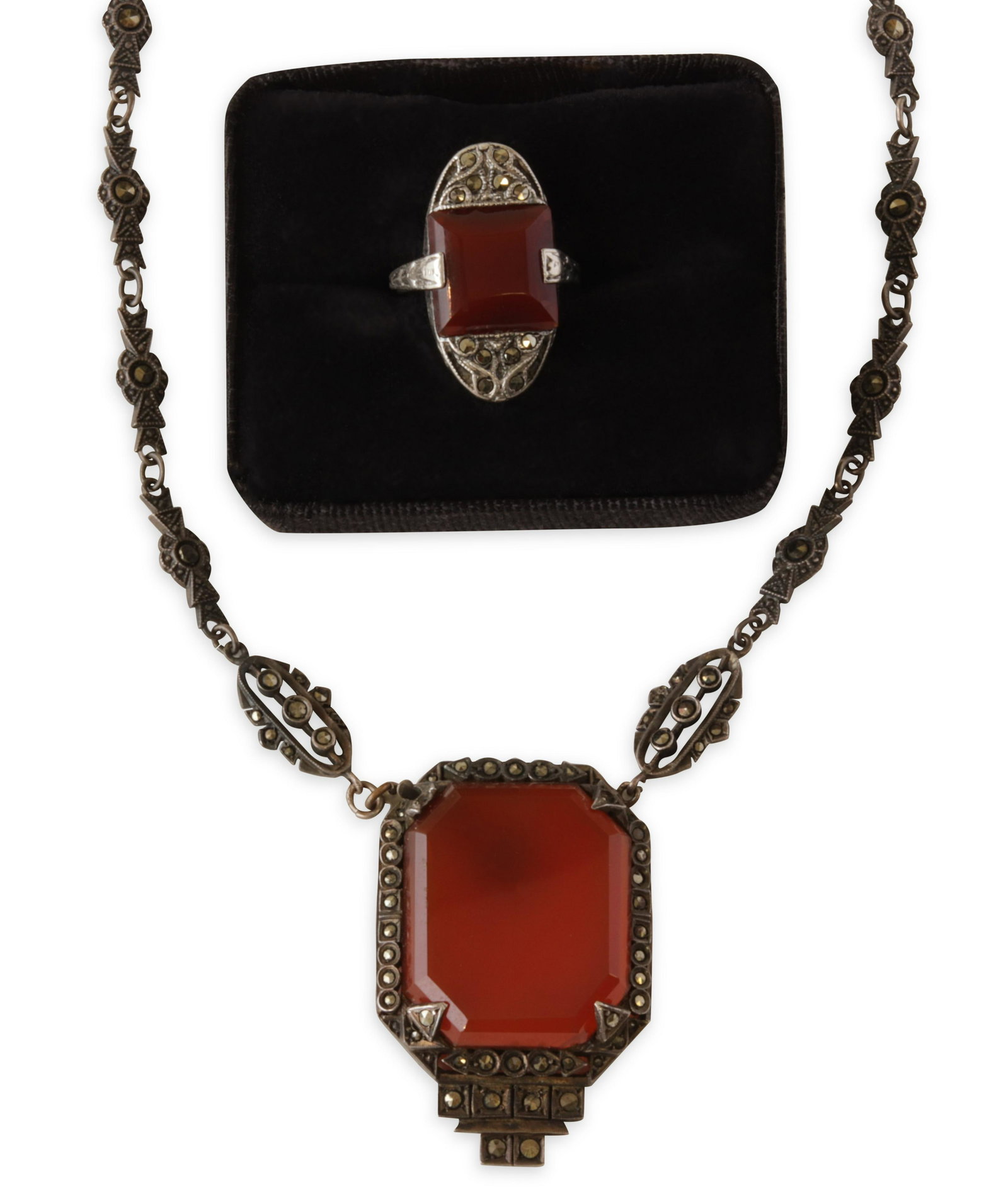 Edwardian Era Carnelian Suite: Necklace with large carnelian pendant measuring 26.48 x 22.01 mm, back stamped Germany. Together with a ring, carnelian measuring 11.50 mm square. Settings unmarked for composition. Gross weight of 29