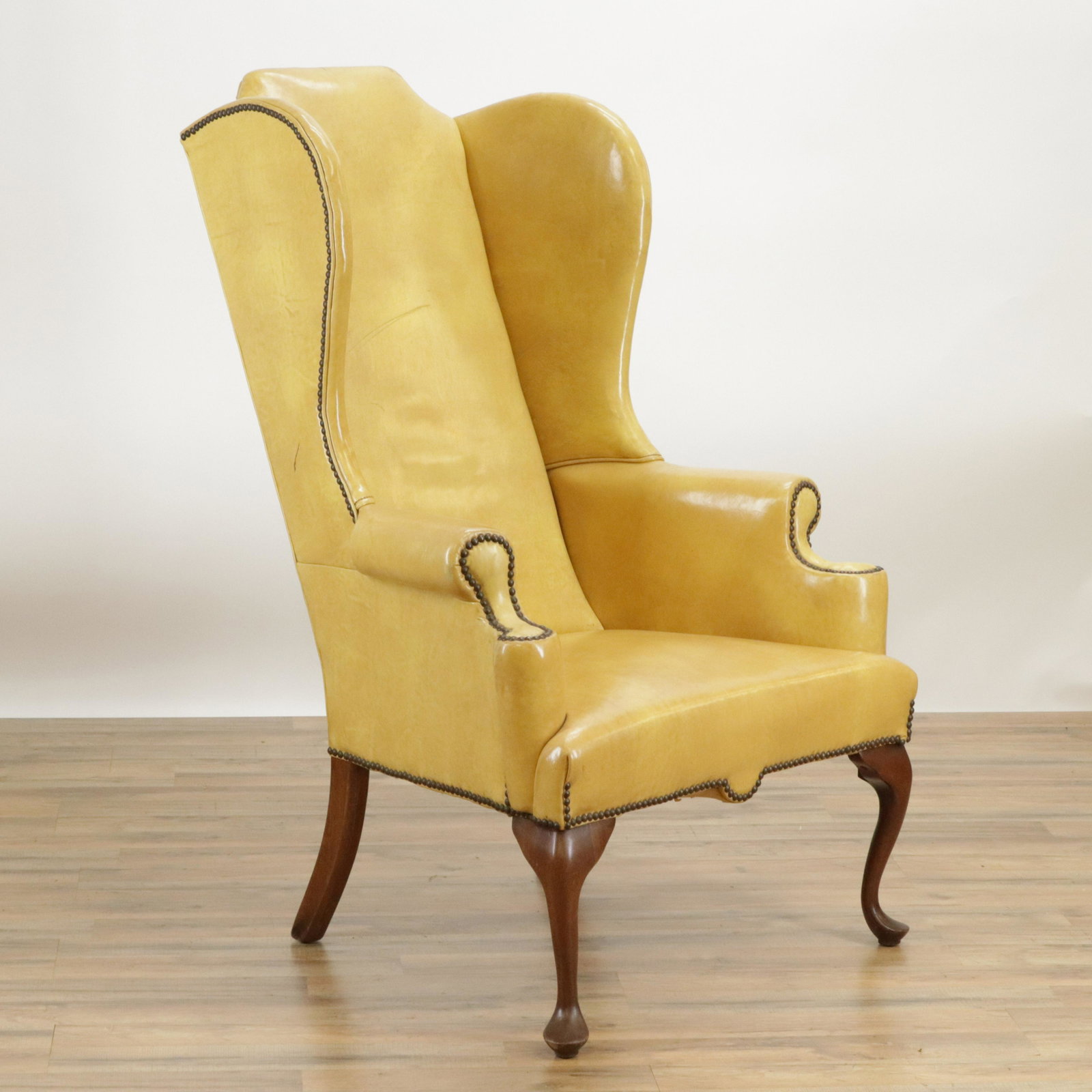 George III Style Mahogany Wing Armchair: George III Style Mahogany Wing Armchair, upholstered in brass buttoned mustard leather (DSEI227)(MS) Dimensions: 51" H x 31" W x 33" D Property from a Litchfield Estate