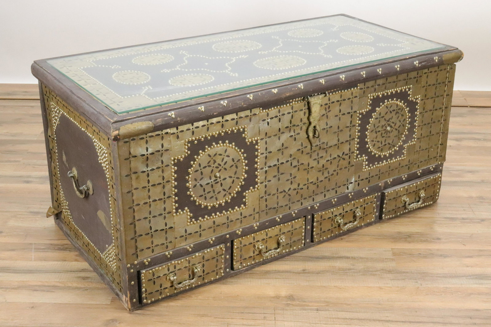 Moroccan Style Dowry Chest, glass top: with glass top,brass nail heads and pierced brass decorations, 4 drawers at base, interior lined with red felted fabric, with lift top storage compartment Dimensions: 19 1/2"H x 45"W x 22"D Proeprty f