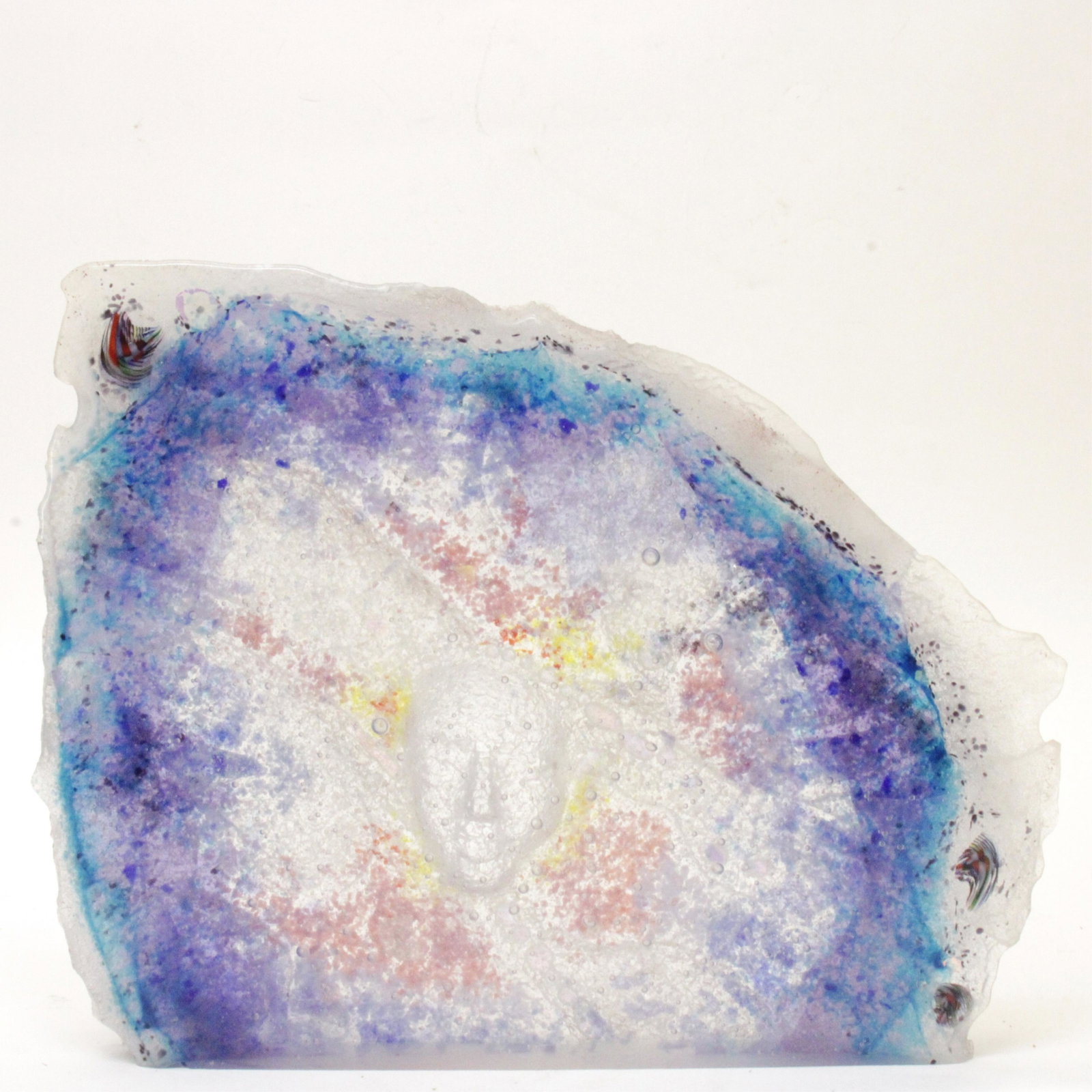 Melanie Rowe, Sculptural Studio Glass (1993): Free-edge three sides, square cut bottom, rough cast verso, polished front. Bubbled/seeded glass, color from within and direct application verso. Face image convex to front view. Millefiori-like areas
