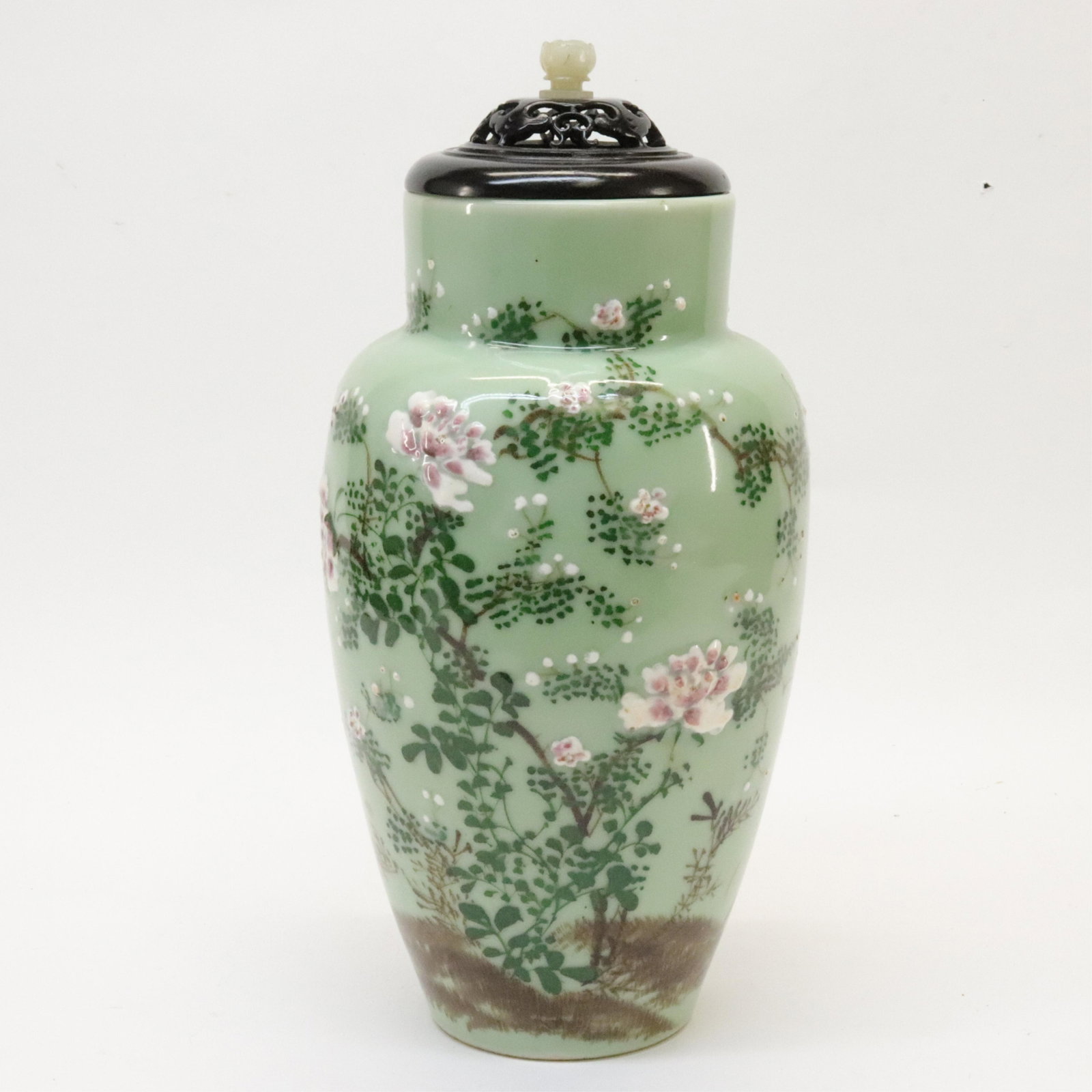 Celadon Porcelain Vase: Celadon Porcelain Vase, 20th century Likely Japanese. With a later added carved wooden lid (likely Chinese), and a carved wooden stand. Dimensions::7" diameter Property from a Colts Neck, New Jersey c
