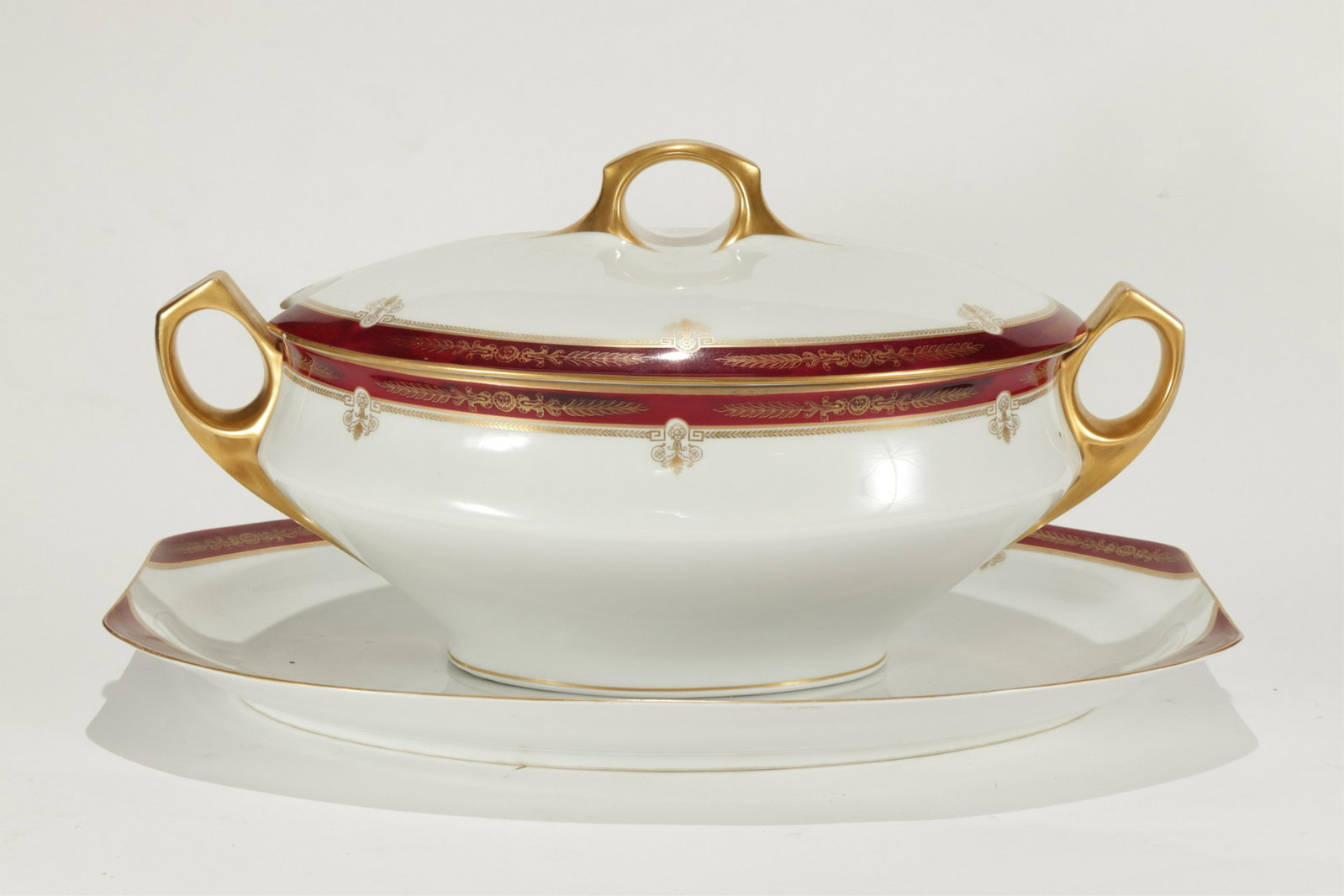 Bauscher Bros. Regina Covered Tureen & Underplate: Bauscher Bros. New York and Weiden (Germany). Porcelain decorated in burgundy and gold on white. Dimensions: 18"L x 11.5W x 9H Property from a West Cornwall, CT Estate