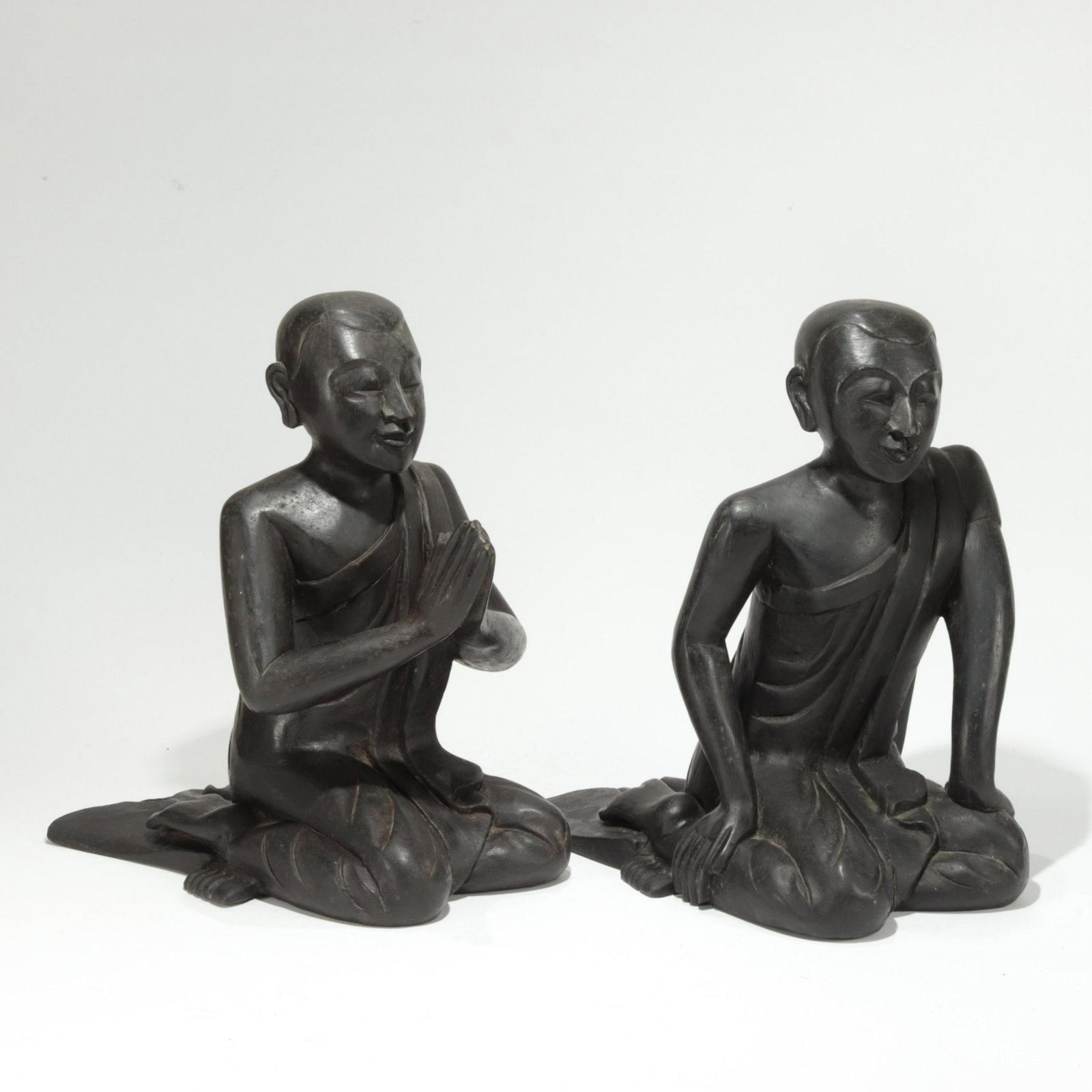 Two Wood Burmese Kneeling Monks: 20th century; Gracefully carved in ebonized wood (ALOE324)(PR) Property from the estate of a retired Asian arts gallery owner 12" high each