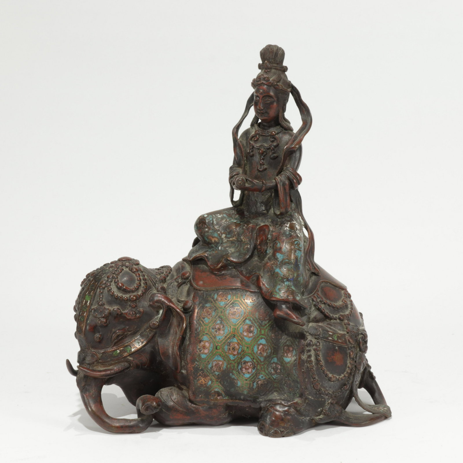 Chinese Bronze ChamplevÃ© Guanyin Riding Elephant: 19th to early 20th century, Well cast figure holding a scroll and seated in the typical style astride a lying elephant. The robe, saddle carpet, and harness straps are carved and enameled. No marks. (