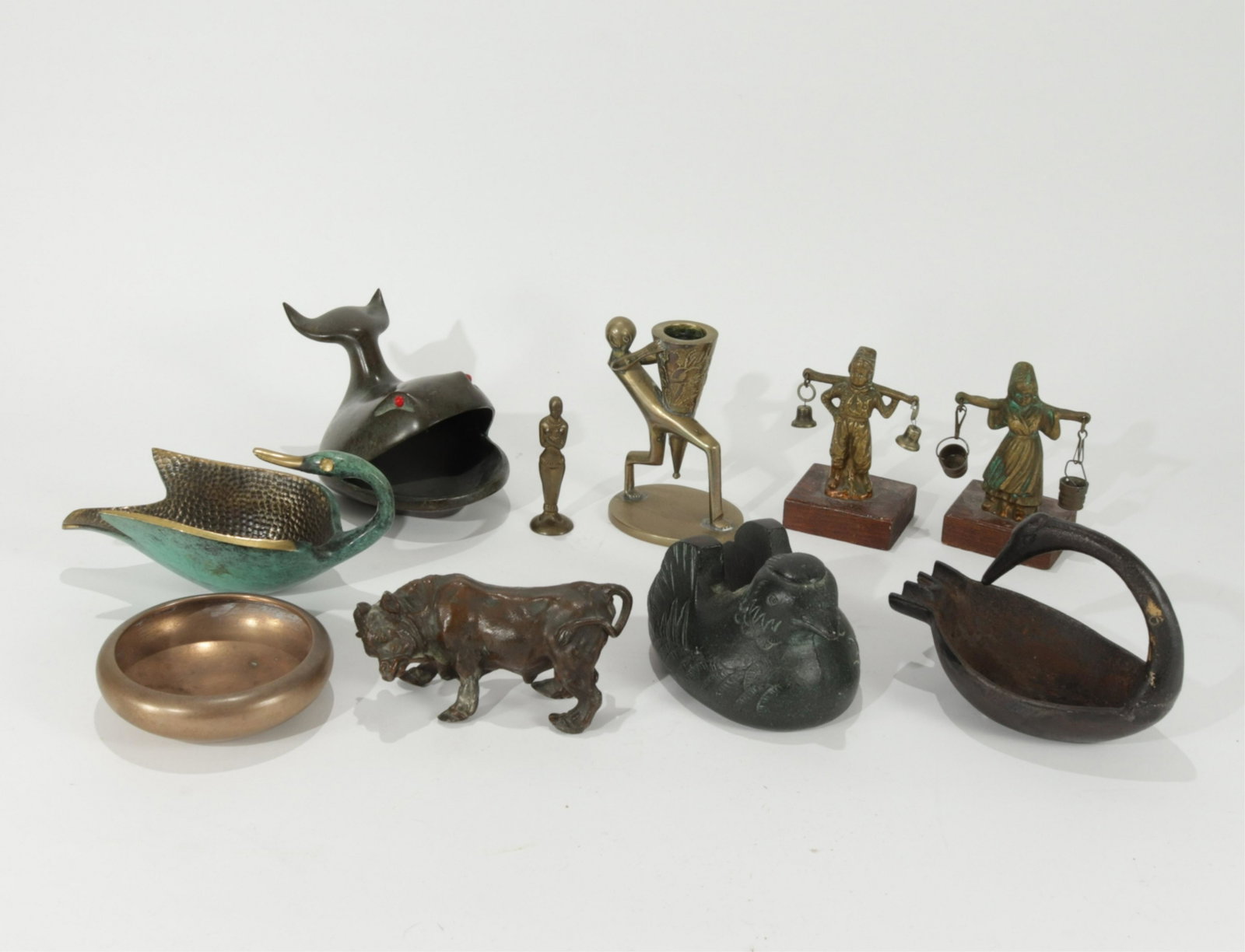 Collection 20th c Metal Decorative Objects: Pal Bell Co swan 7 by 3. Cast iron swan 5.5 y 4. 1-Japanese painted iron screen holder, 4.5 by 3. 1-Chinese brass candlestick, 4 by 4.5. 2-Dutch children 3.5 h by 2.75, includes wood base. 1- German f