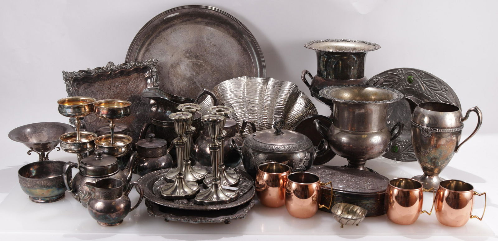 Large Lot of Silver Plate Pieces: Including pitchers, trays, shaped bowls, wine coolers, handled cups, partial tea set and more.Dimensions: Smallest 3" to largest 18" dia. Clamshell; 16.5" Shipping is the buyer's responsibility! We re