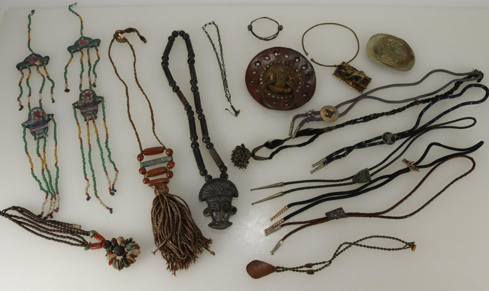 Group of Boleros, Necklaces and more: Group of Boleros, Necklaces, a Mexican belt buckle.Dimensions: African; 16" including pendent. Shipping is the buyer's responsibility! We recommend obtaining a quote from a third party shipper prior t