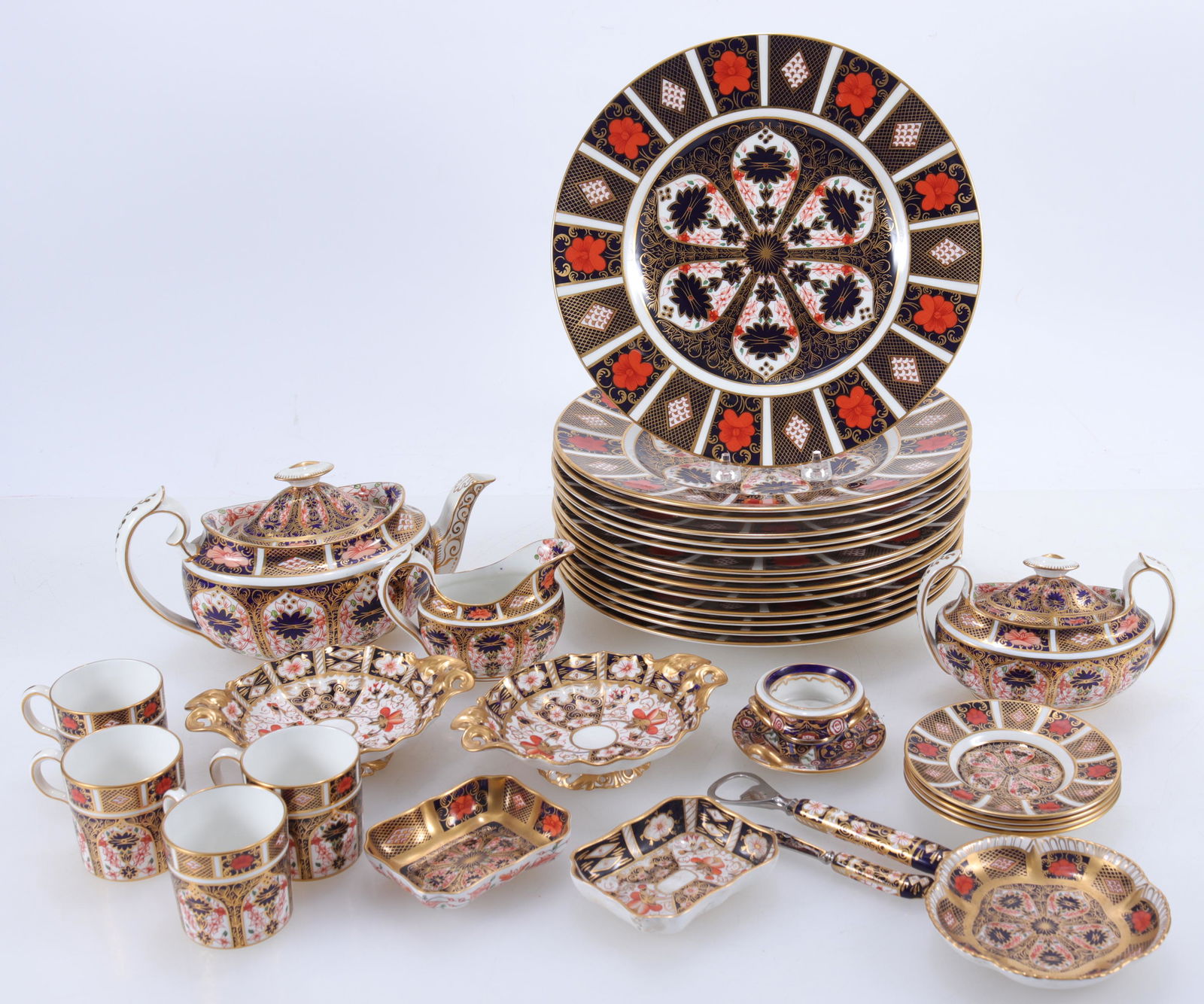 Royal Crown Derby Old Imari Partial Service: Royal Crown Derby Bone China partial porcelain service in Old Imari pattern, number 1128. Includes 14 dinner plates, four cups & saucers, and miscellaneous dishes. Two small pedestal dishes and tea se